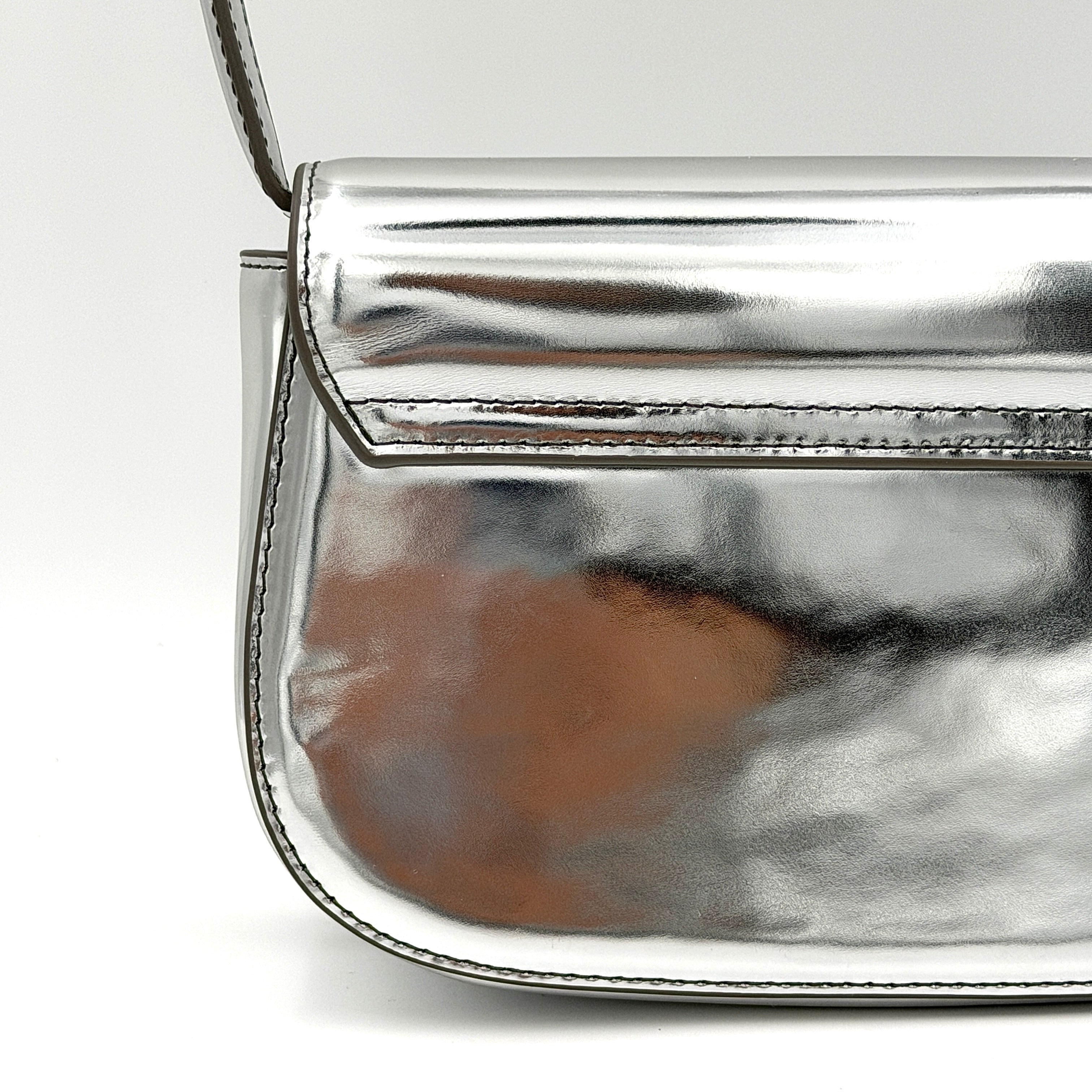 Diesel 1DR 2Way metallic silver shoulder bag with sculptural D logo and detachable strap displayed against a plain background.