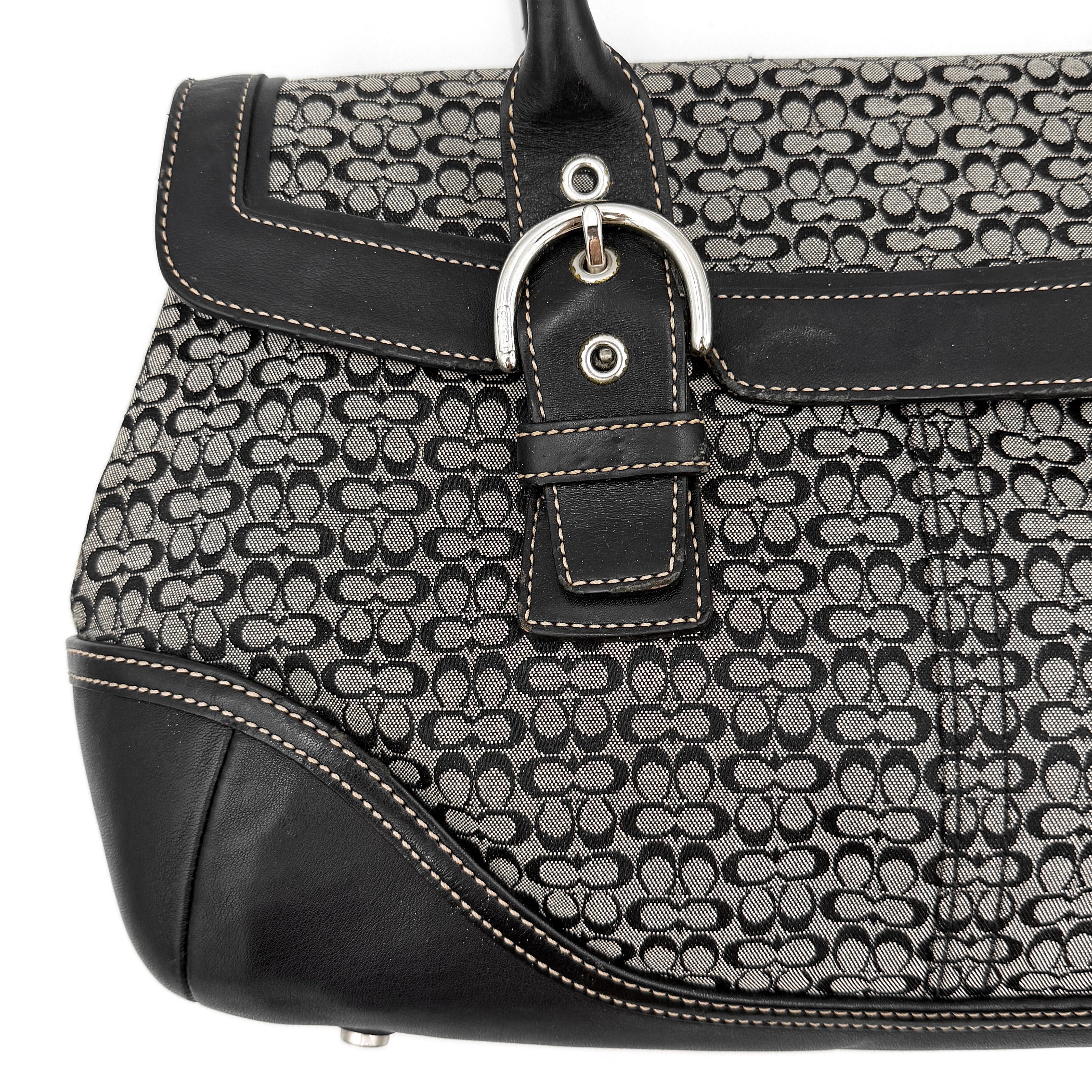 Coach Soho Hampton satchel in grey and black signature jacquard with black leather trim and silver-tone buckle details, presented upright with dual rolled handles.
