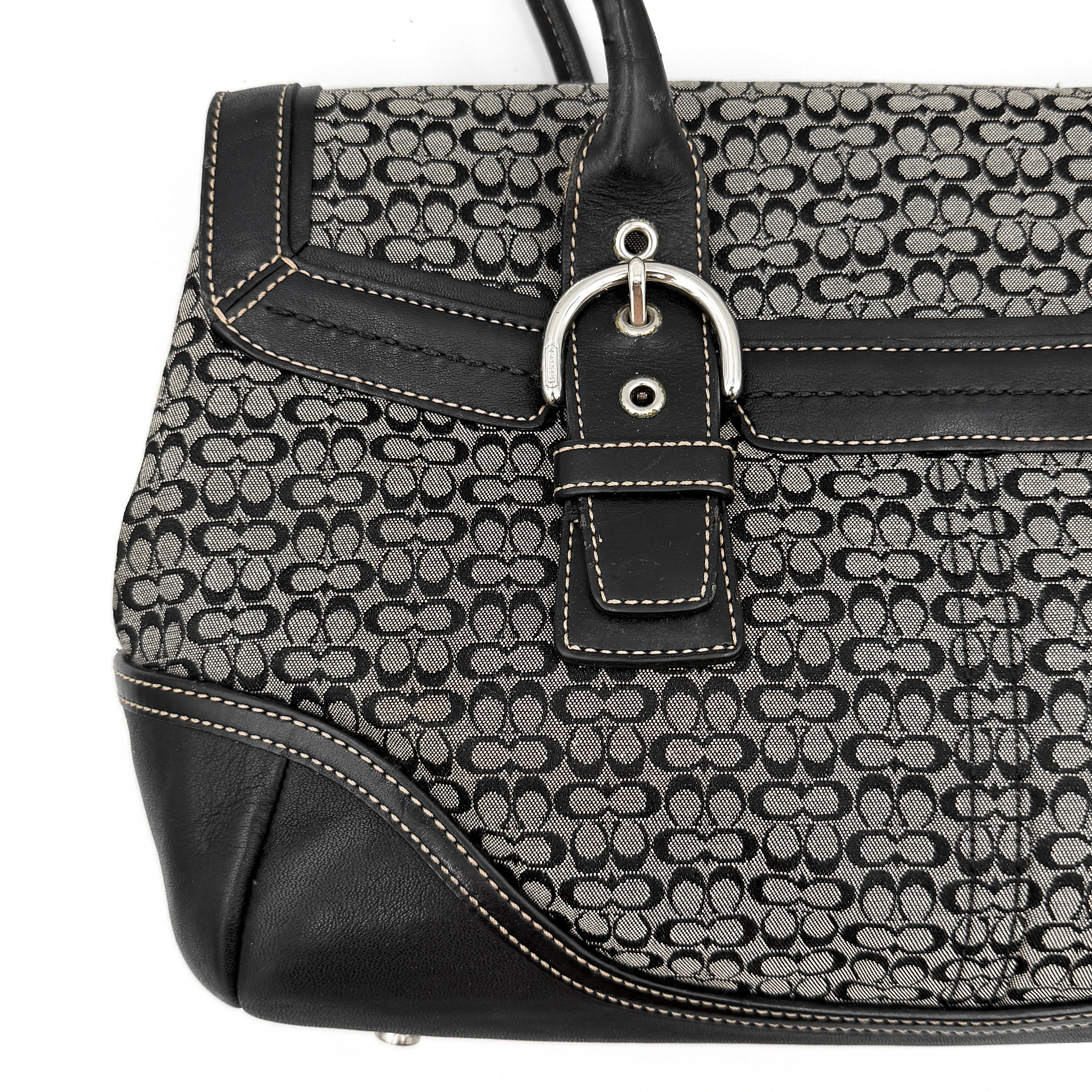 Coach Soho Hampton satchel in grey and black signature jacquard with black leather trim and silver-tone buckle details, presented upright with dual rolled handles.