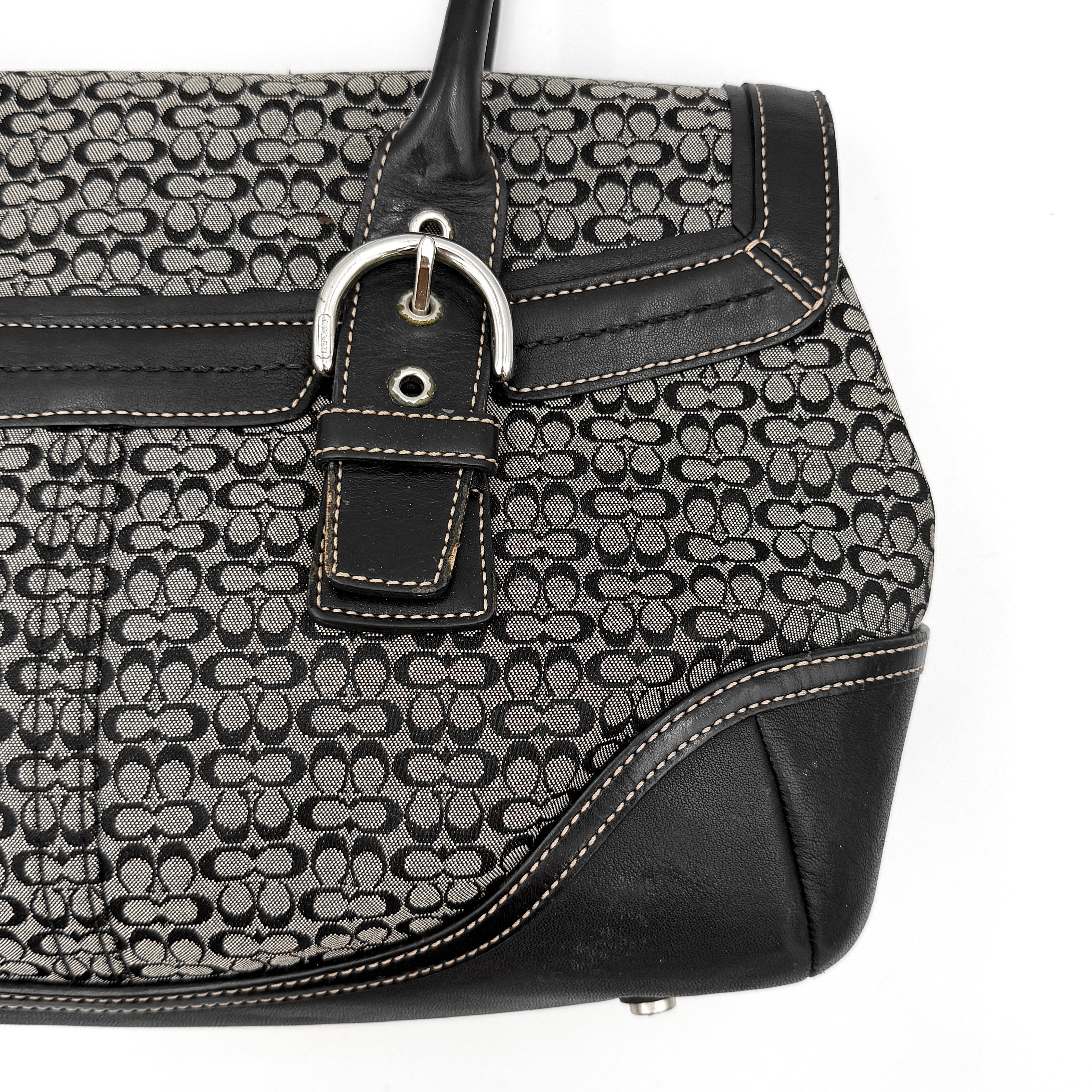 Coach Soho Hampton satchel in grey and black signature jacquard with black leather trim and silver-tone buckle details, presented upright with dual rolled handles.