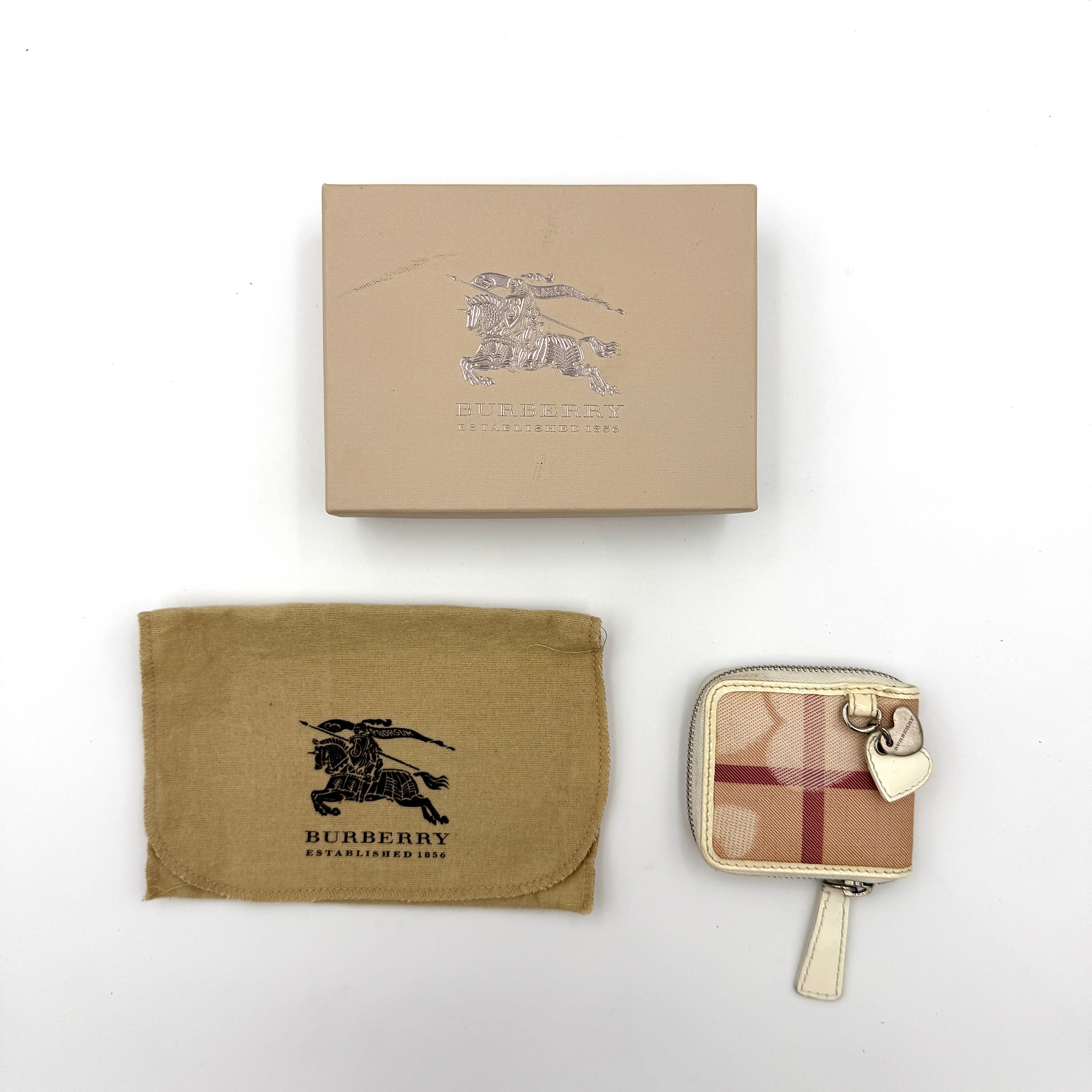 Burberry Heart Nova Check coin case in beige canvas with ivory leather trim and heart charms on the zipper pull.