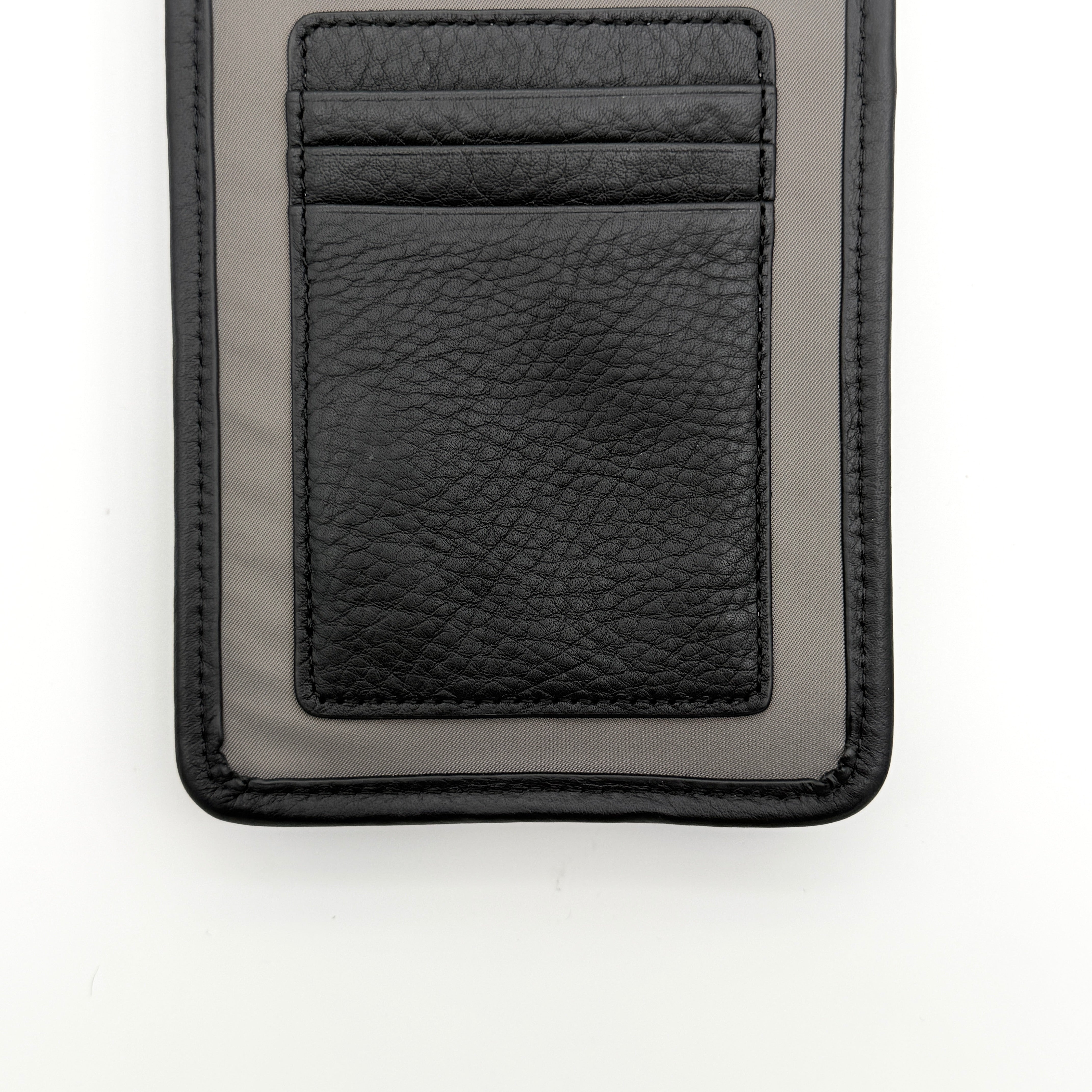 Furla Cosmo grey phone holder with black trim, silver buckle, and black cord strap on white background.