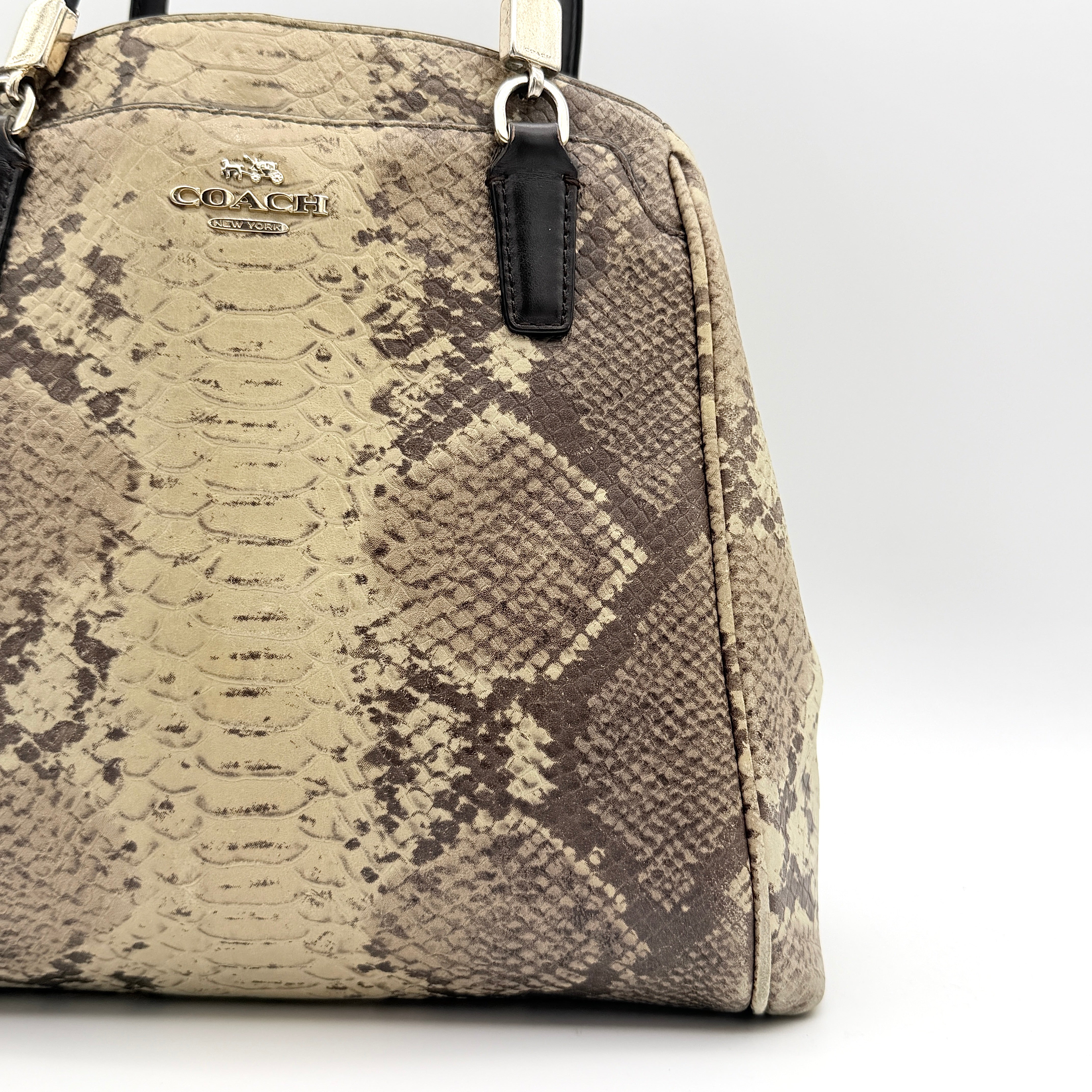 Coach Minetta shoulder bag in python-embossed beige and brown leather with black handles and gold-tone hardware.
