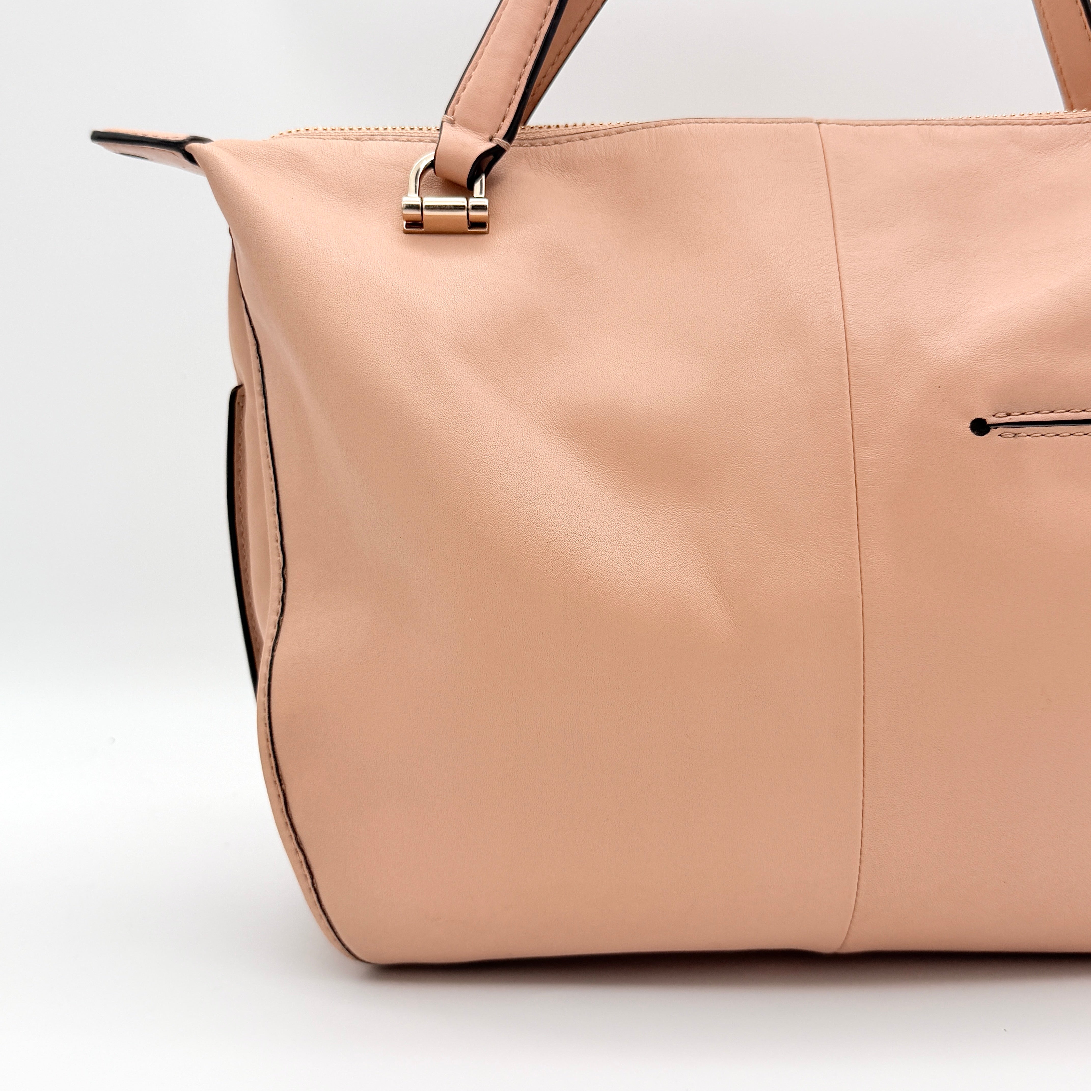 Coach Madison Smythe satchel in blush pink leather with gold-tone hardware and detachable strap, displayed against a white background.