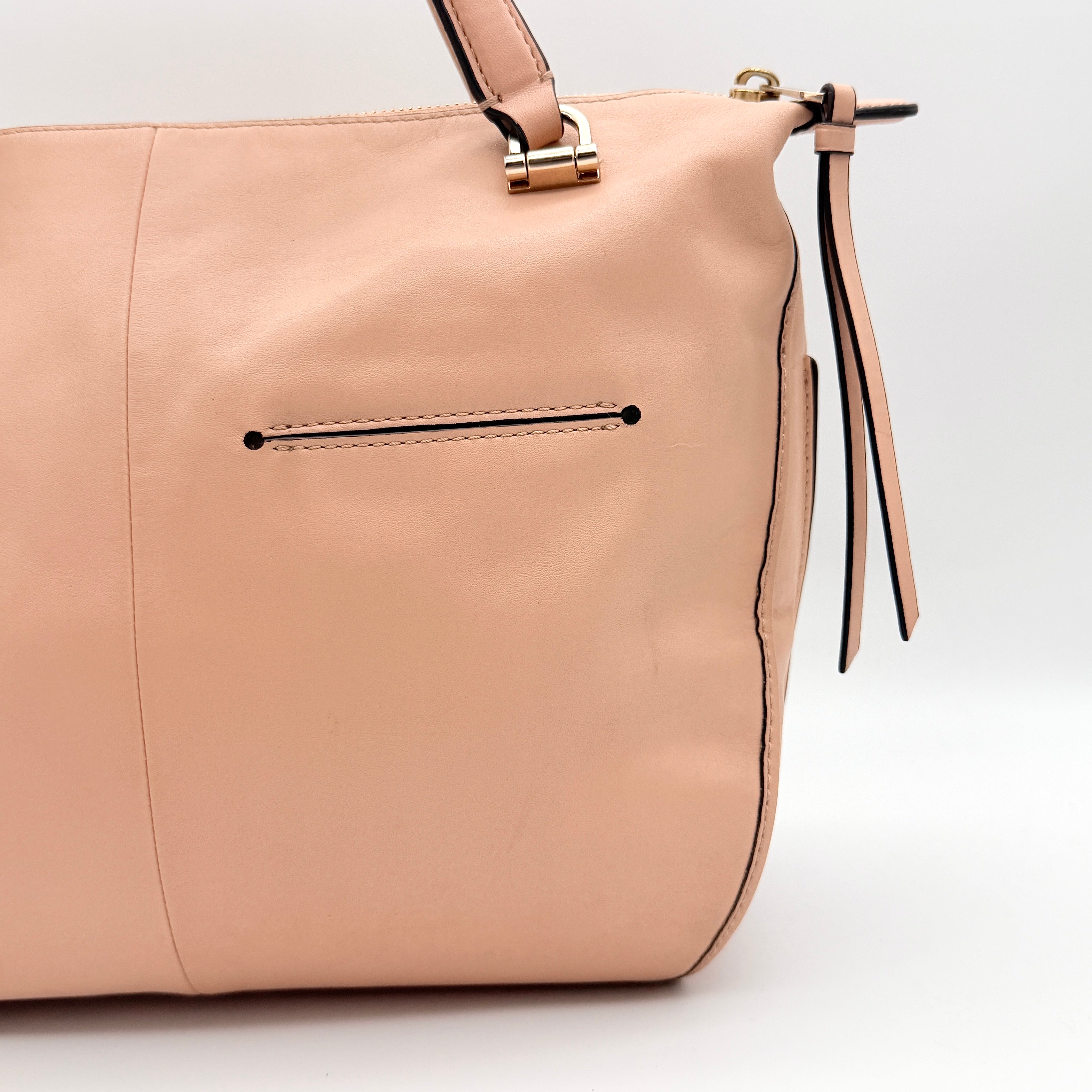 Coach Madison Smythe satchel in blush pink leather with gold-tone hardware and detachable strap, displayed against a white background.