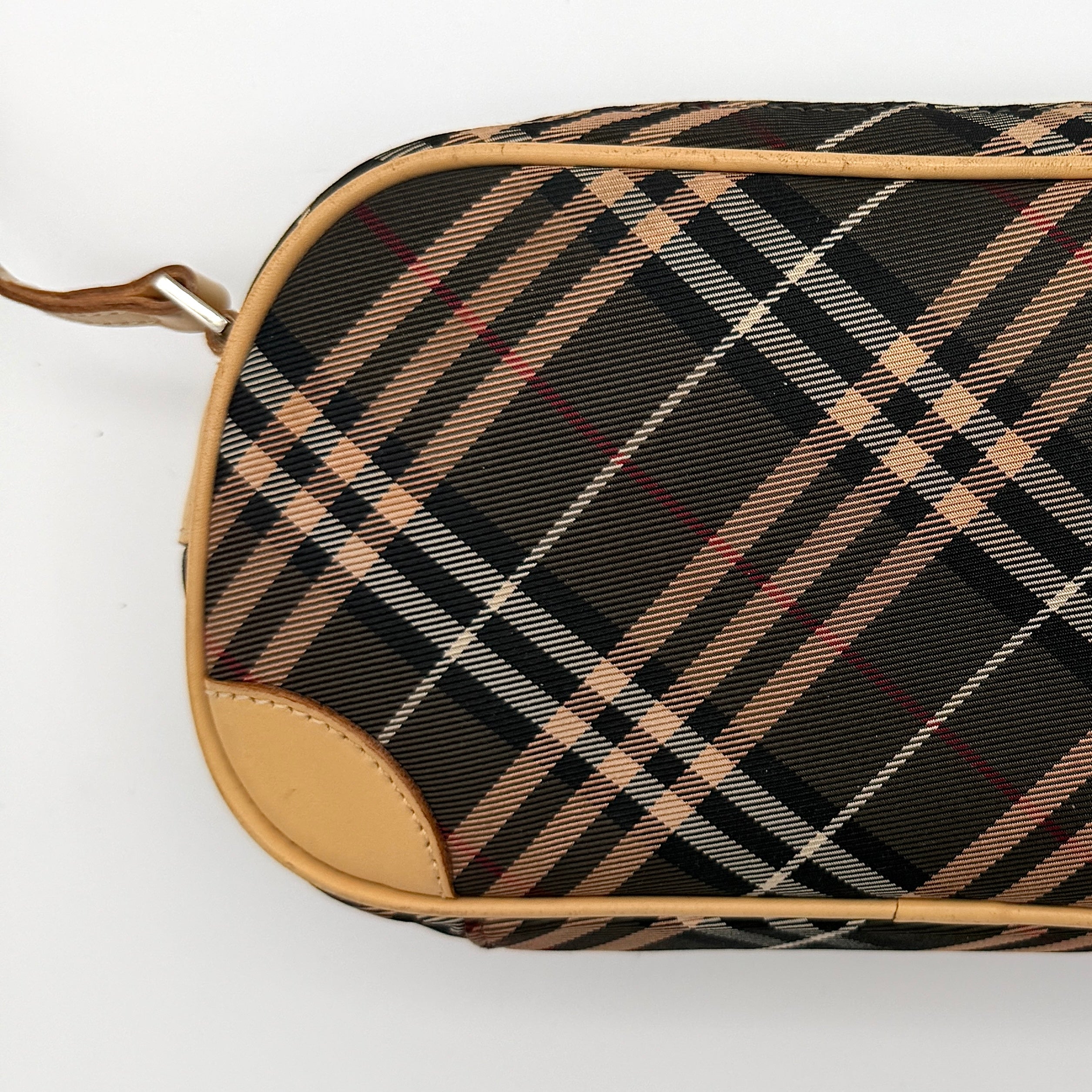 Burberry Blue Label Nova Check crossbody bag with tan leather trim and heart charm, styled on a white background.