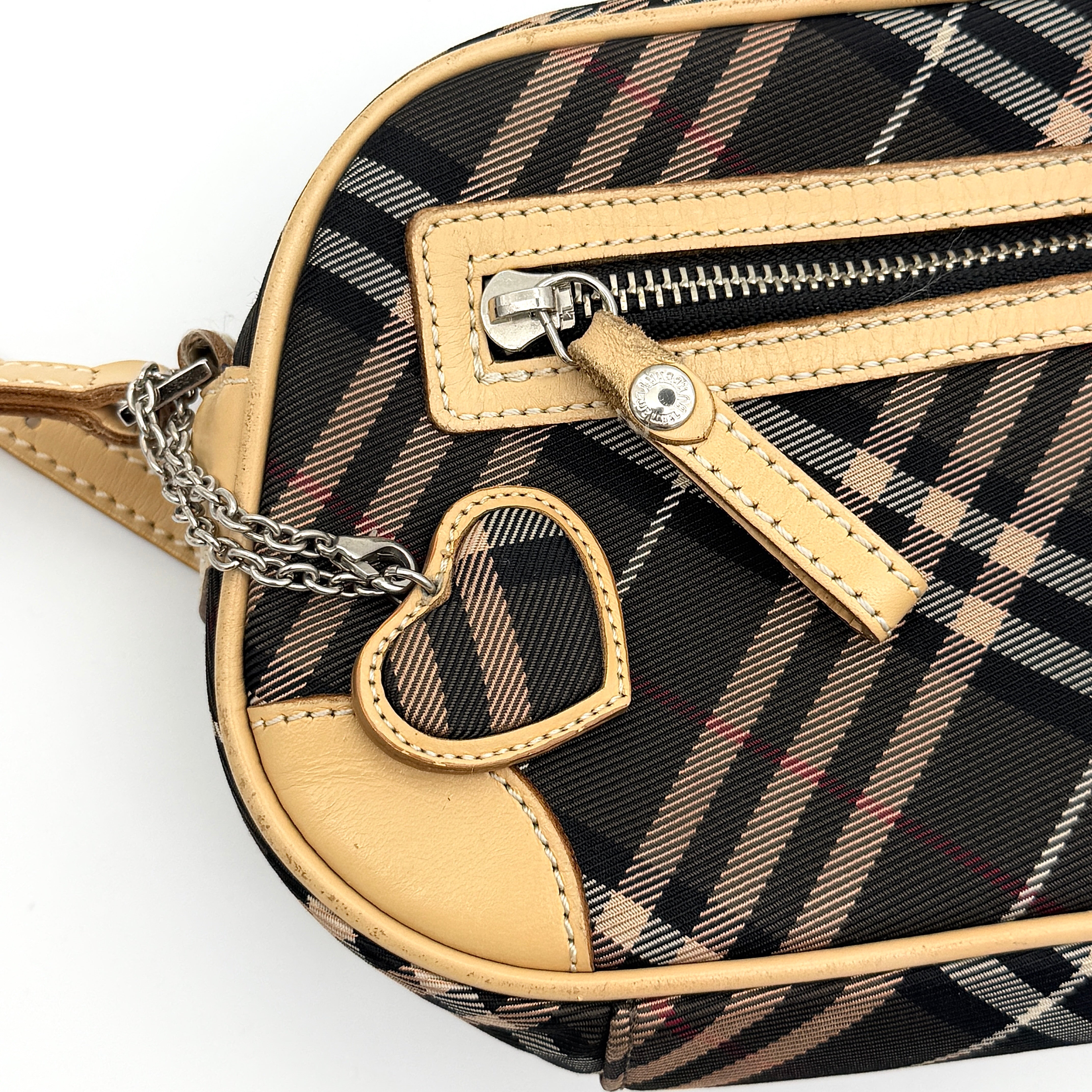 Burberry Blue Label Nova Check crossbody bag with tan leather trim and heart charm, styled on a white background.