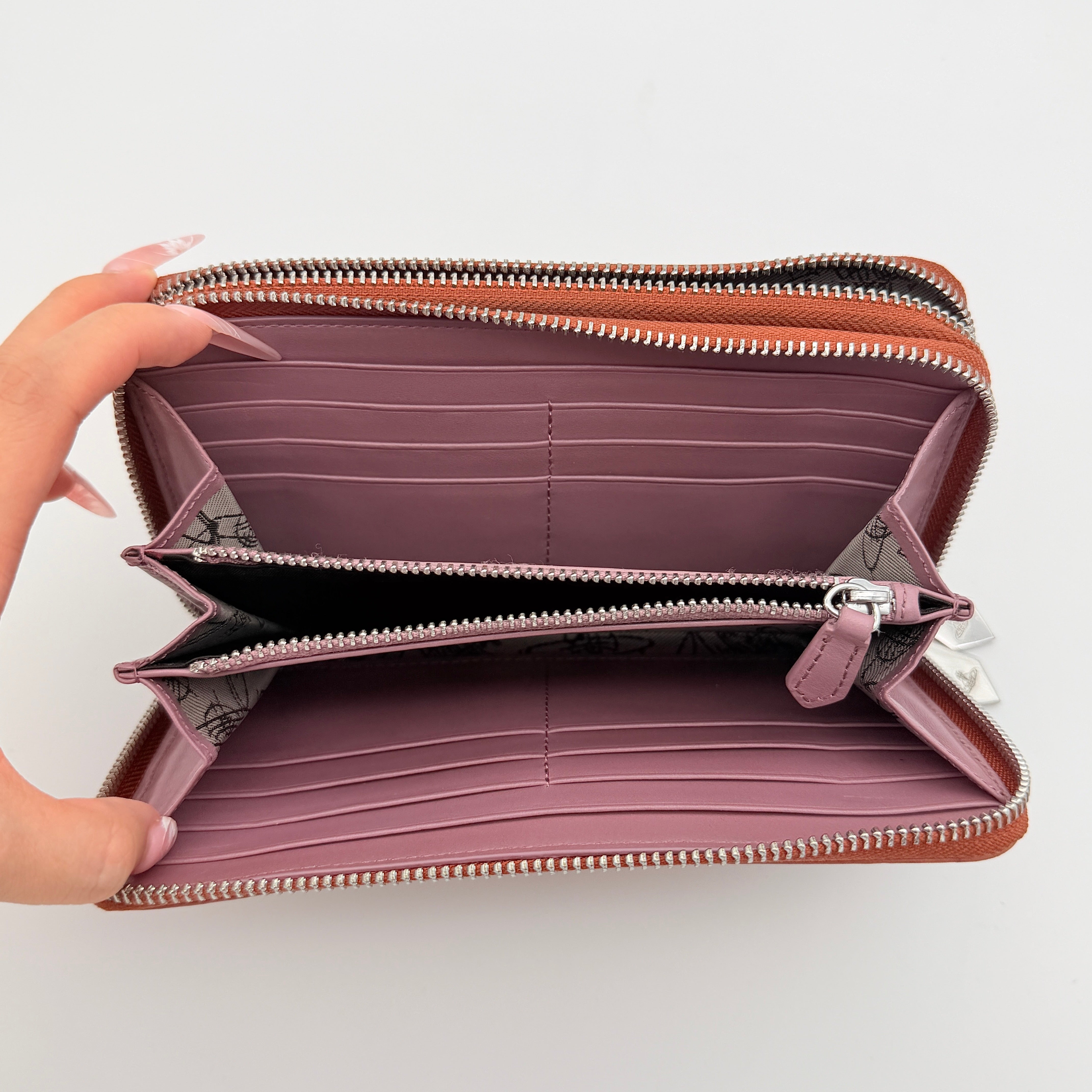 Vivienne Westwood 2Way Signature Orb Embossed Shoulder Wallet in coral pink leather with removable shoulder strap, shown with silver hardware.