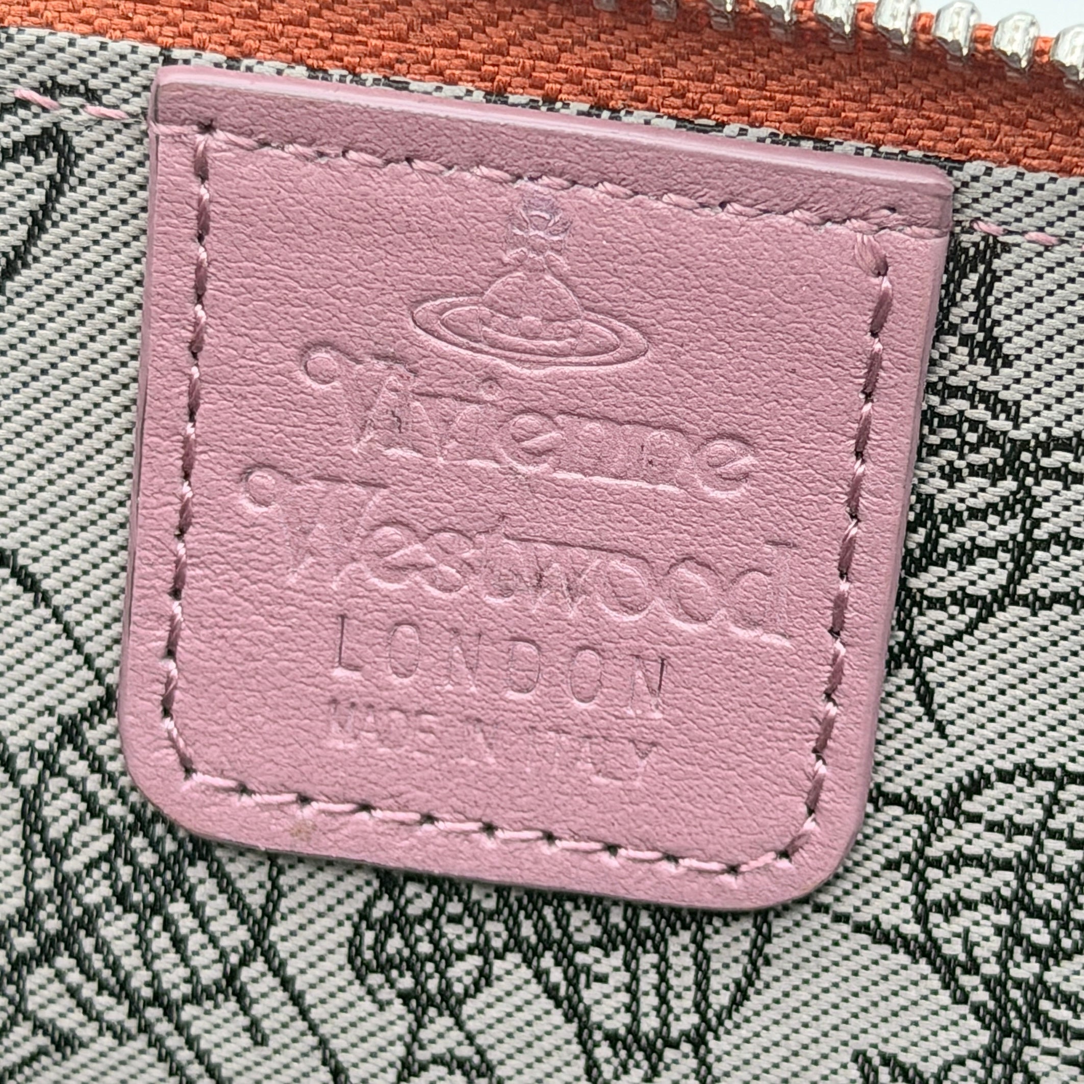 Vivienne Westwood 2Way Signature Orb Embossed Shoulder Wallet in coral pink leather with removable shoulder strap, shown with silver hardware.