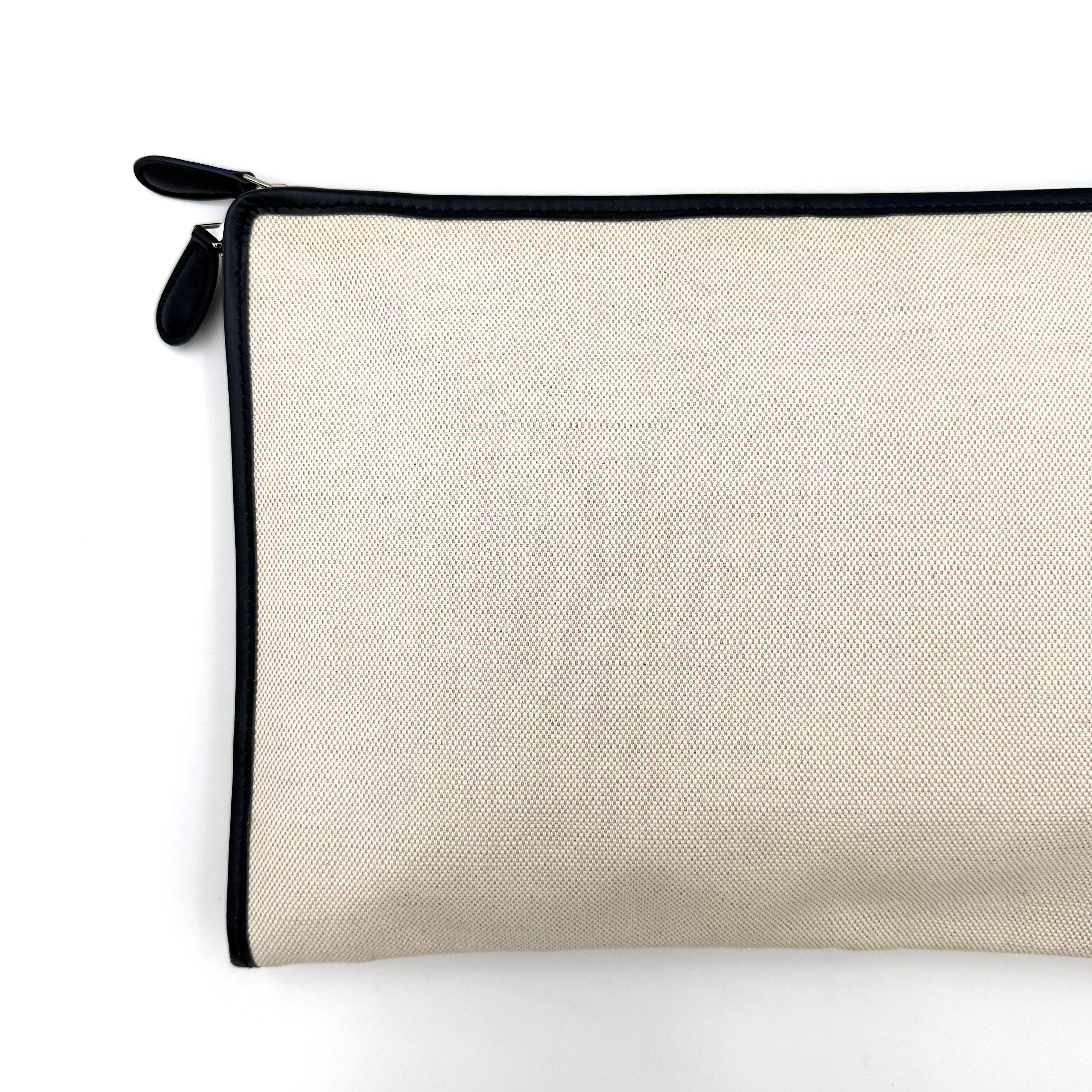 Balenciaga large ivory canvas clutch with black leather trim and logo, shown against a plain background.