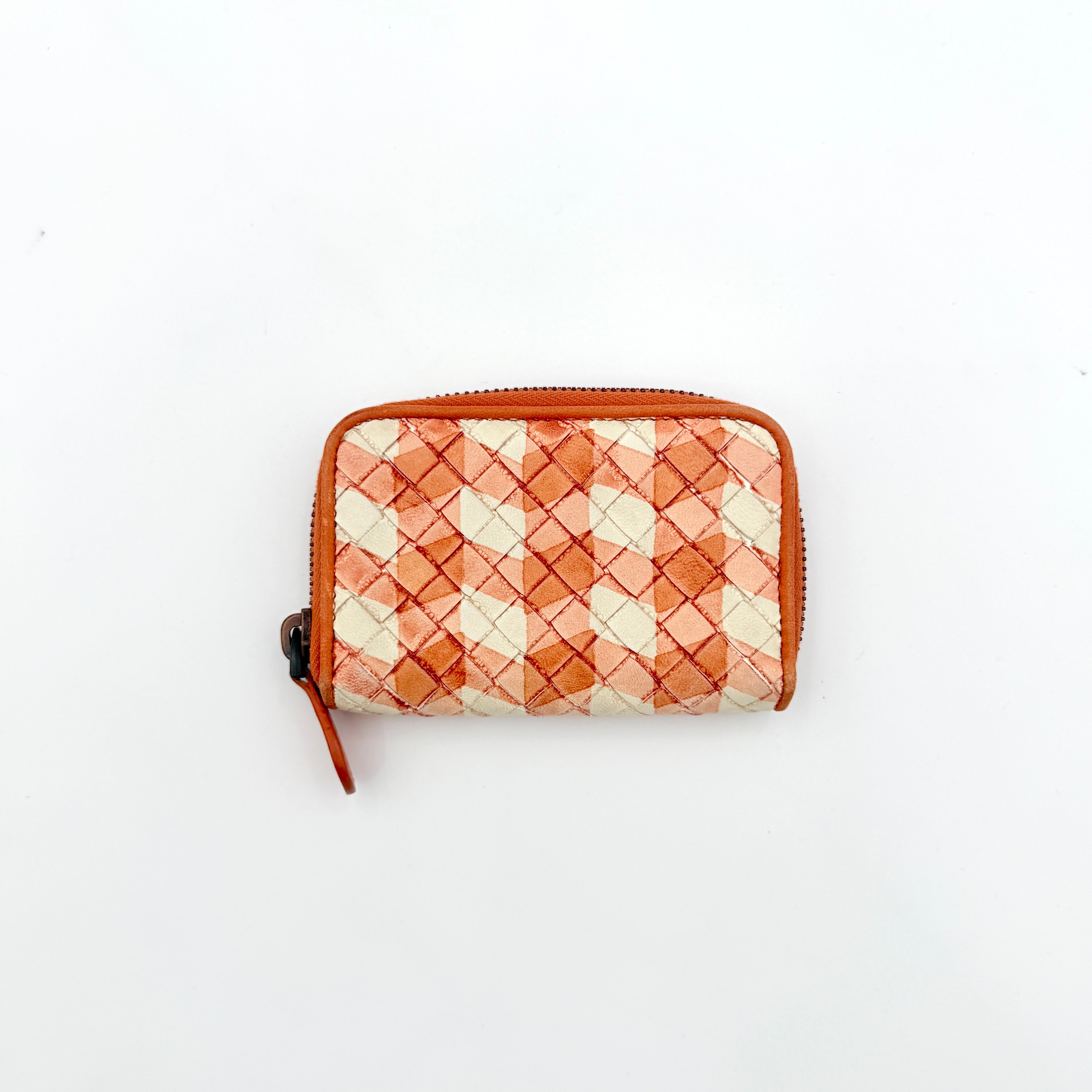 Front view of the Bottega Veneta Intrecciato zip around wallet in orange and white woven leather.
