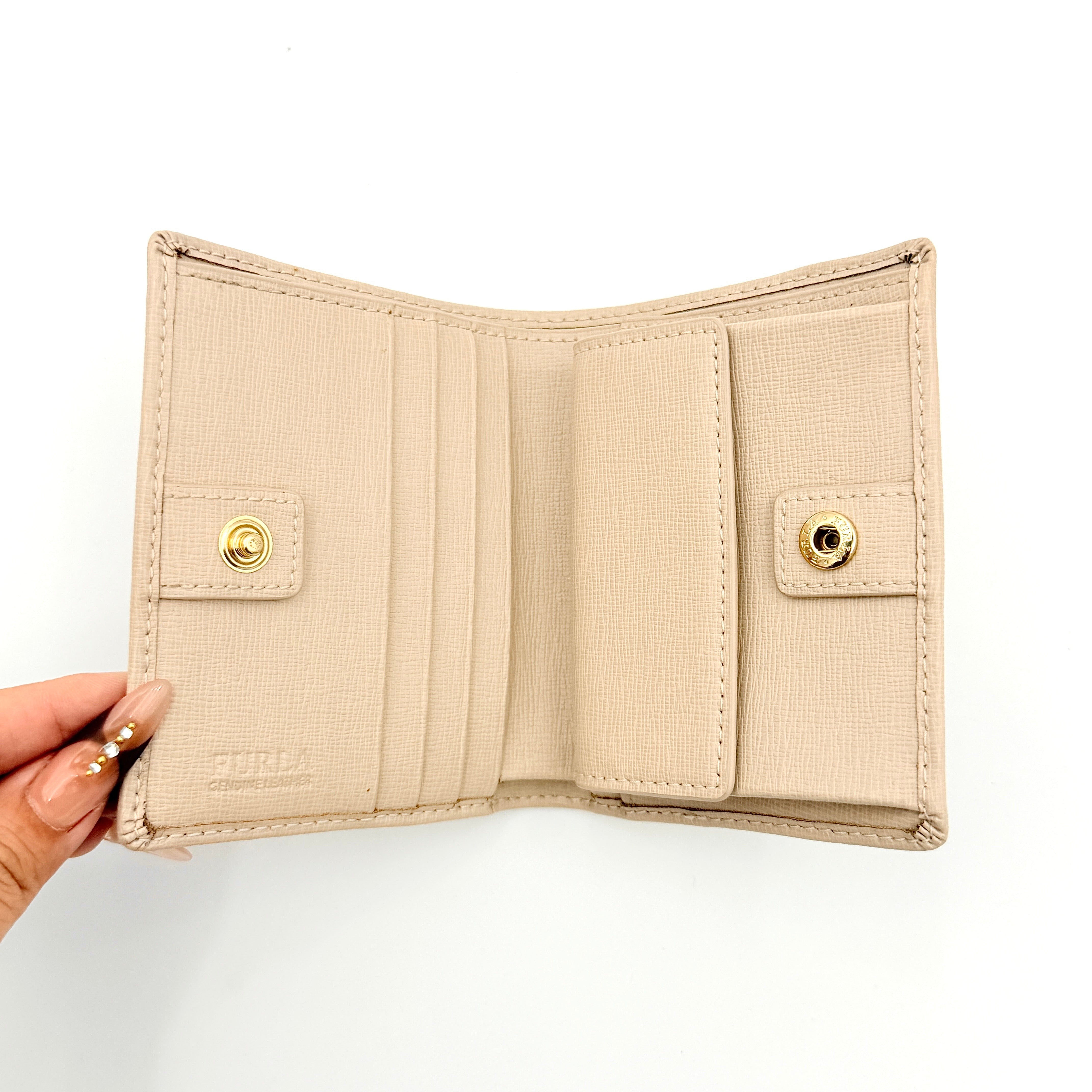 Furla Camelia S Compact Wallet in beige leather with gold-tone logo plaque, photographed against a clean white background.