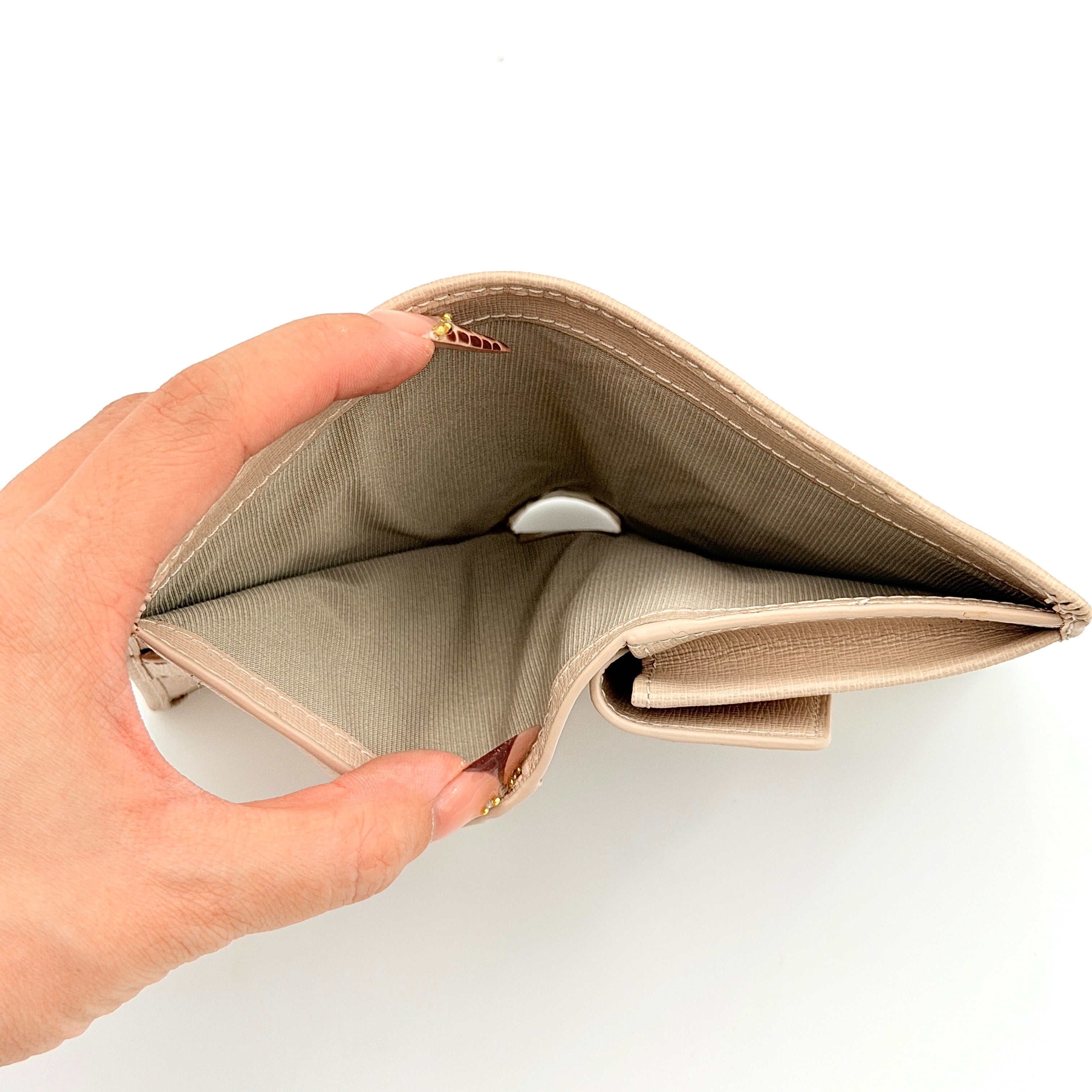 Furla Camelia S Compact Wallet in beige leather with gold-tone logo plaque, photographed against a clean white background.