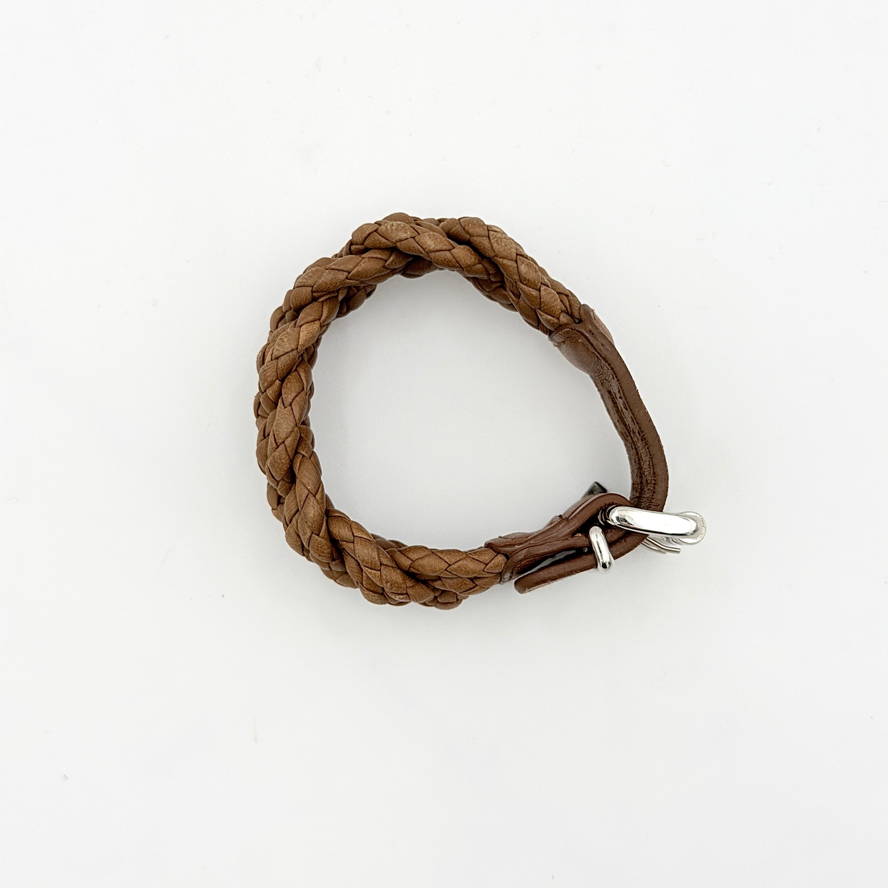 Bottega Veneta brown braided leather bracelet with silver-tone double buckle, displayed on a clean background.