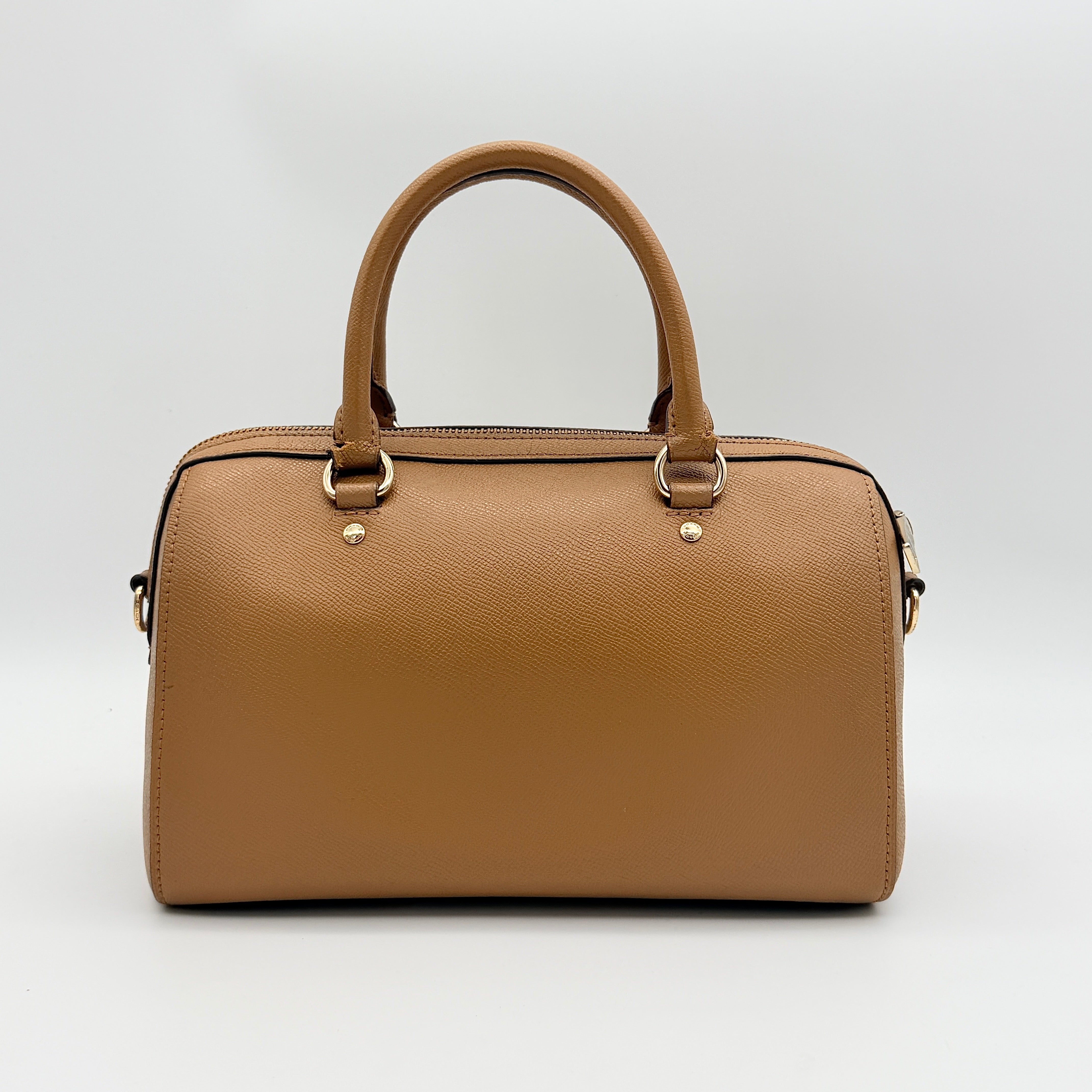 Coach Rowan satchel in brown grained leather with gold hardware, shown with dust bag, strap, and care cards.
