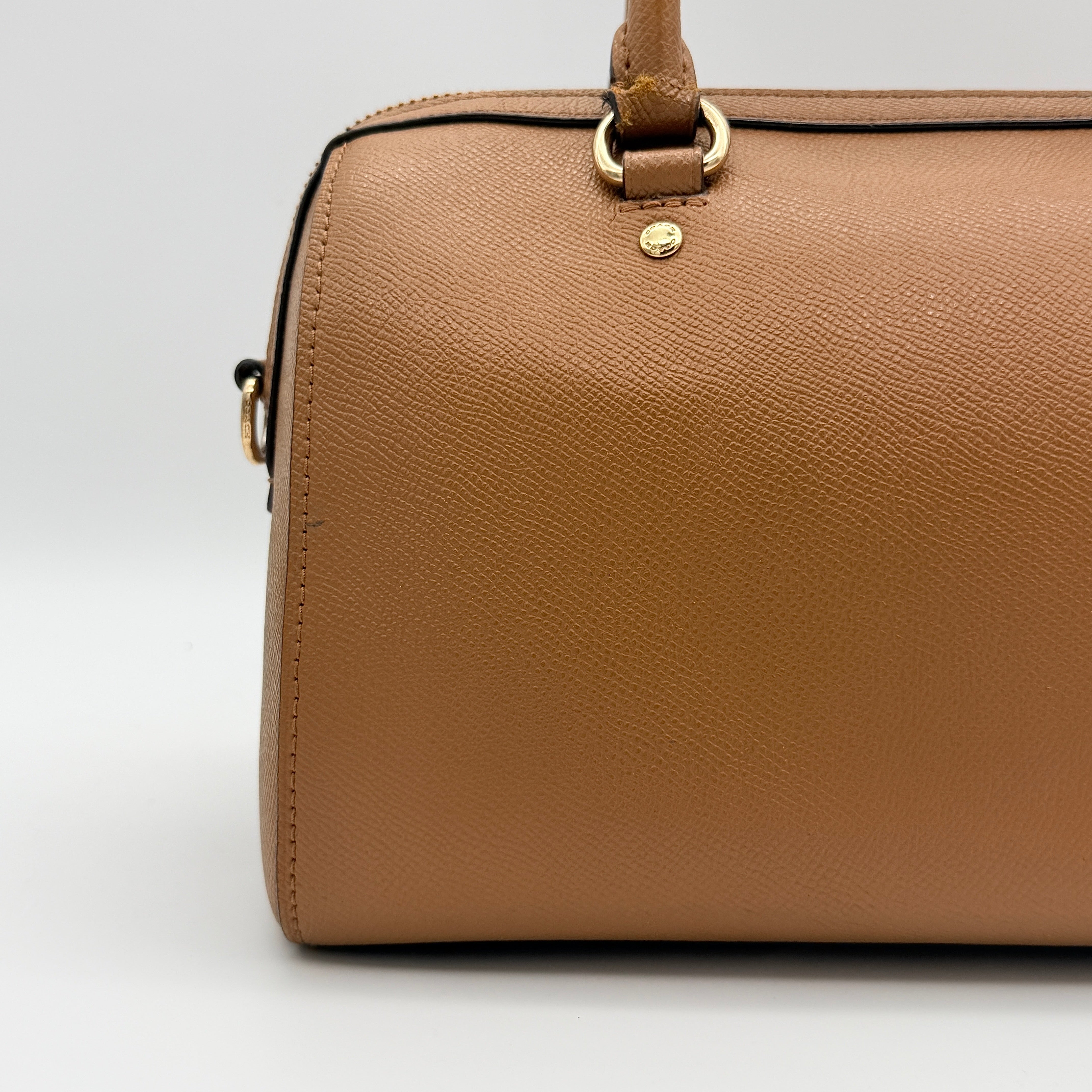 Coach Rowan satchel in brown grained leather with gold hardware, shown with dust bag, strap, and care cards.