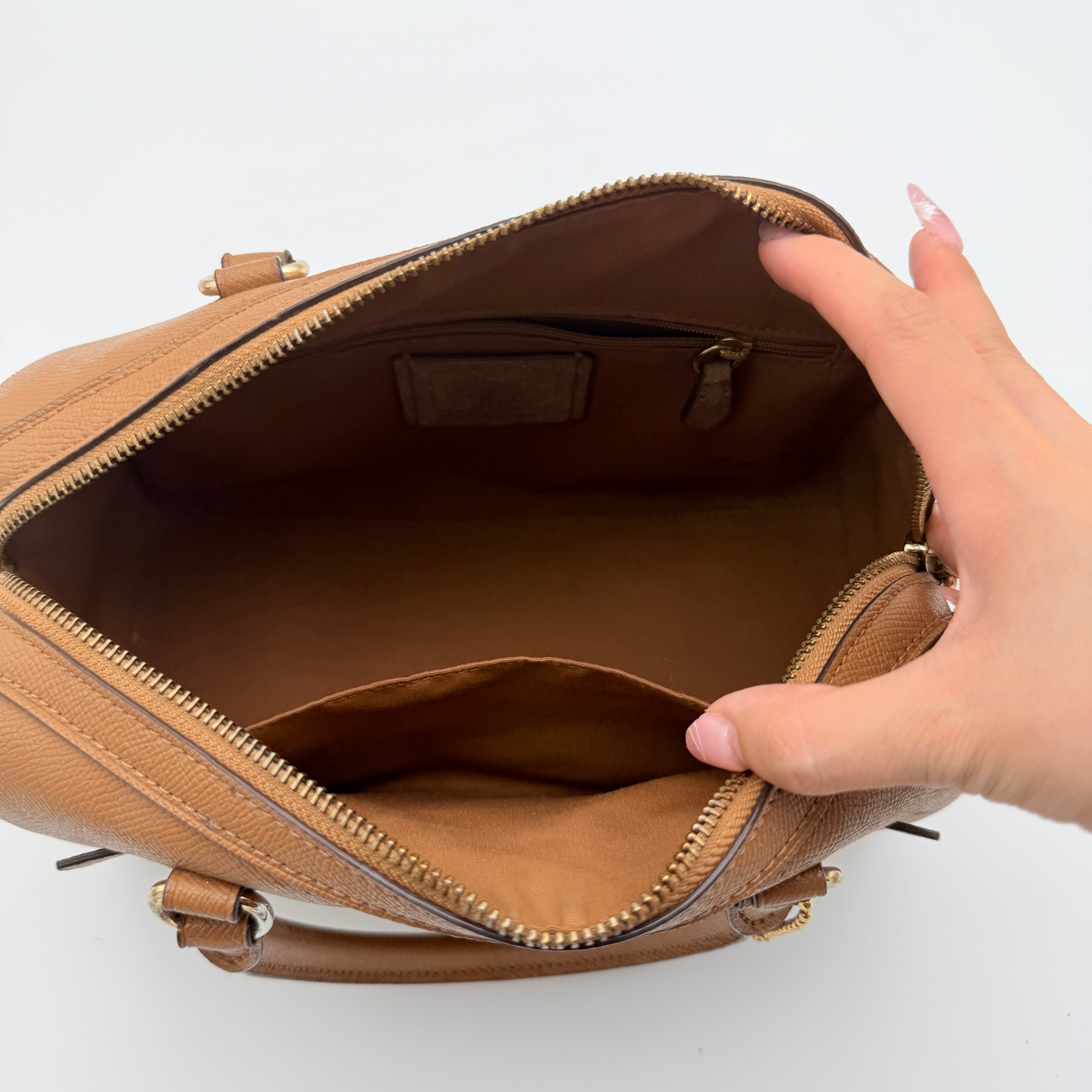 Coach Rowan satchel in brown grained leather with gold hardware, shown with dust bag, strap, and care cards.
