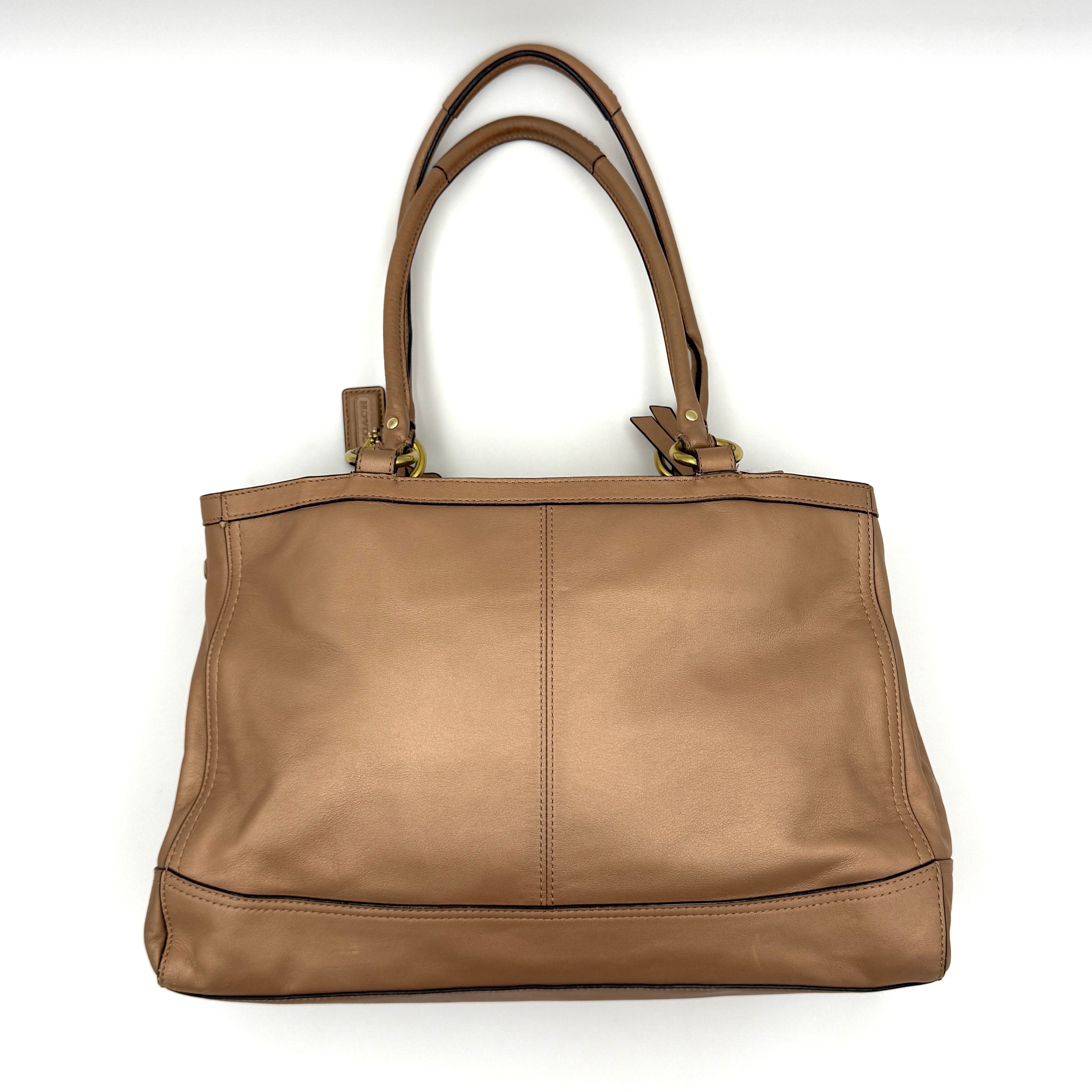 Coach Park Leather Carryall in beige leather with gold-tone hardware and double handles, styled with signature Coach hangtags.