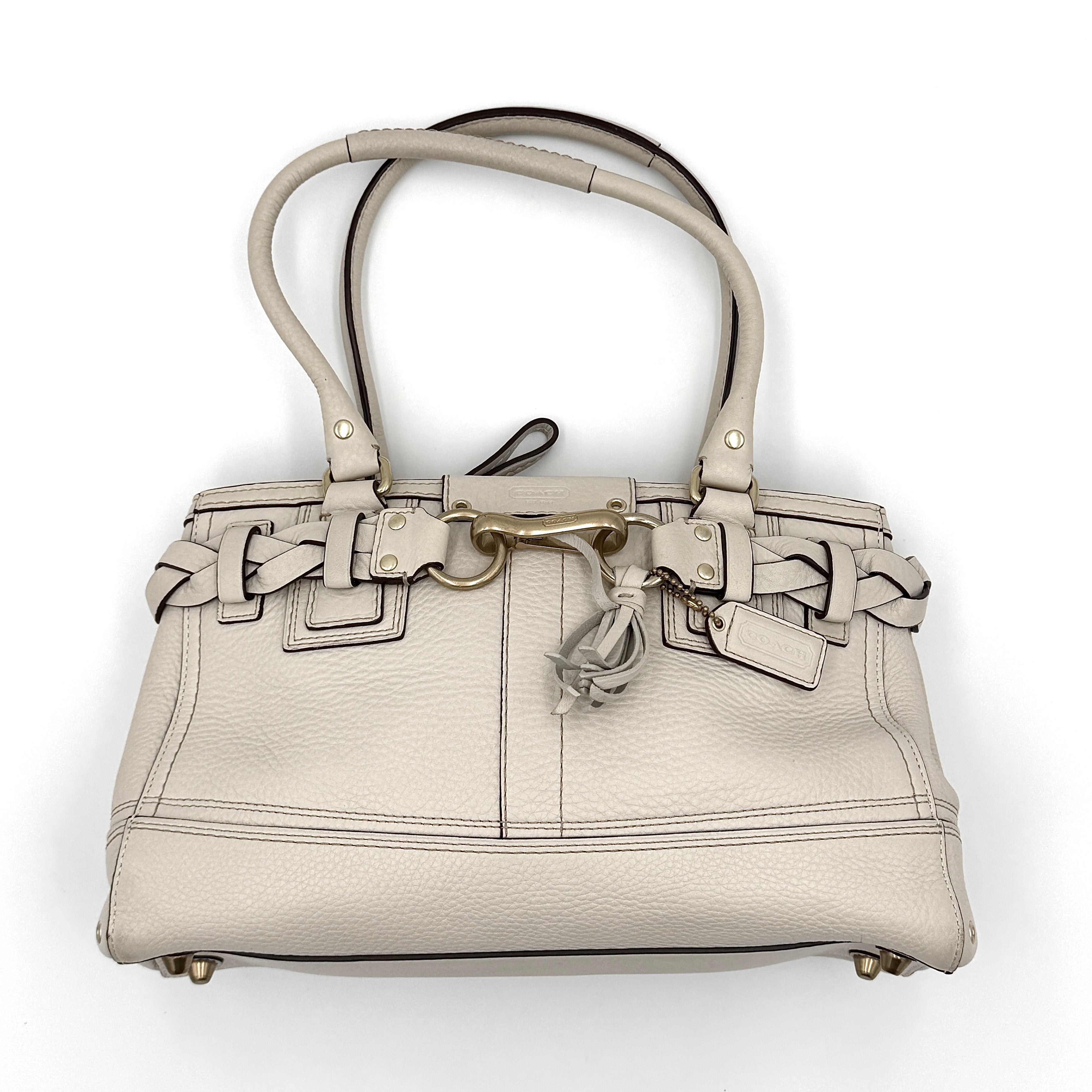 Coach Signature Hampton Carryall Shoulder Bag in ivory pebbled leather with gold-tone hardware and braided detailing, shown from the front.