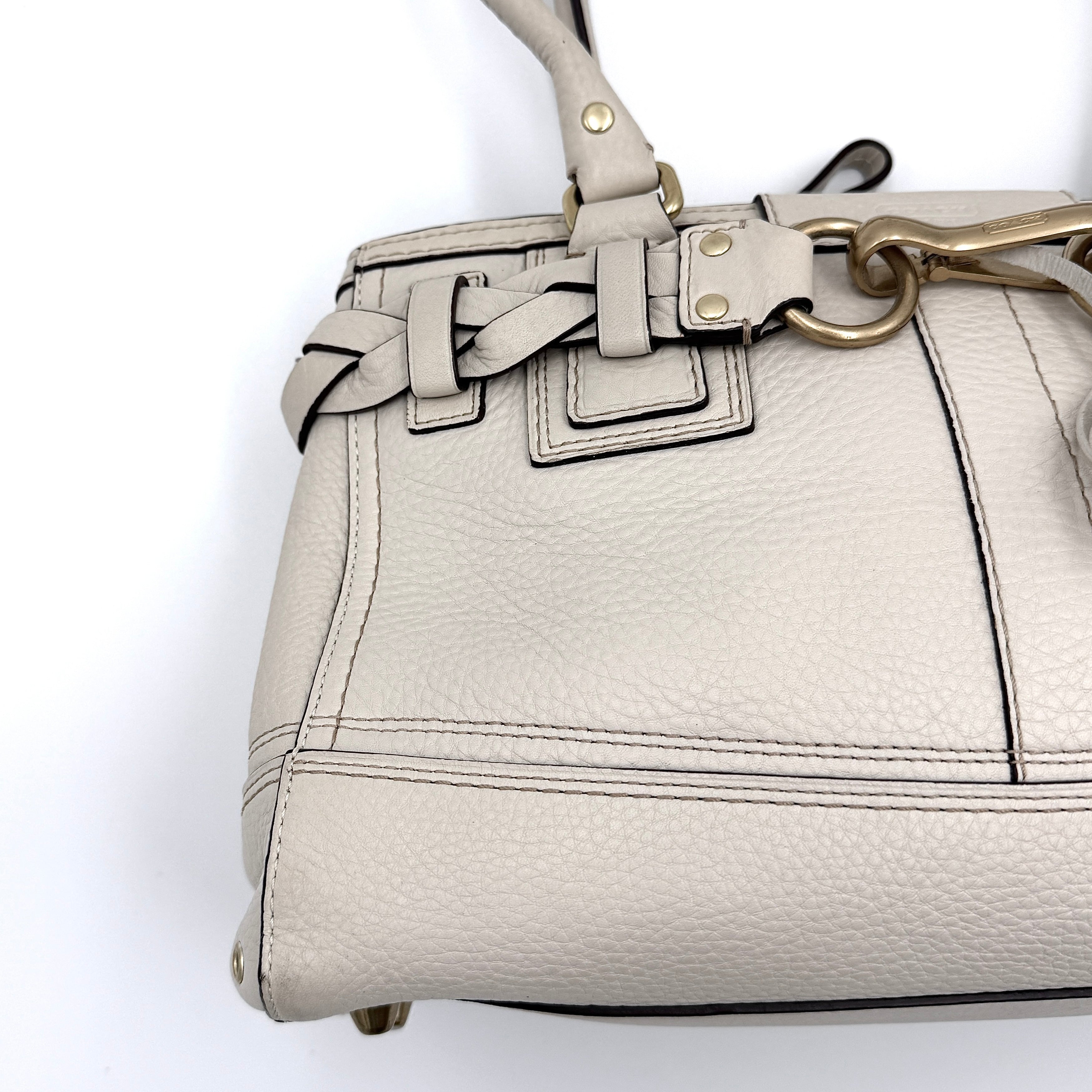 Coach Signature Hampton Carryall Shoulder Bag in ivory pebbled leather with gold-tone hardware and braided detailing, shown from the front.