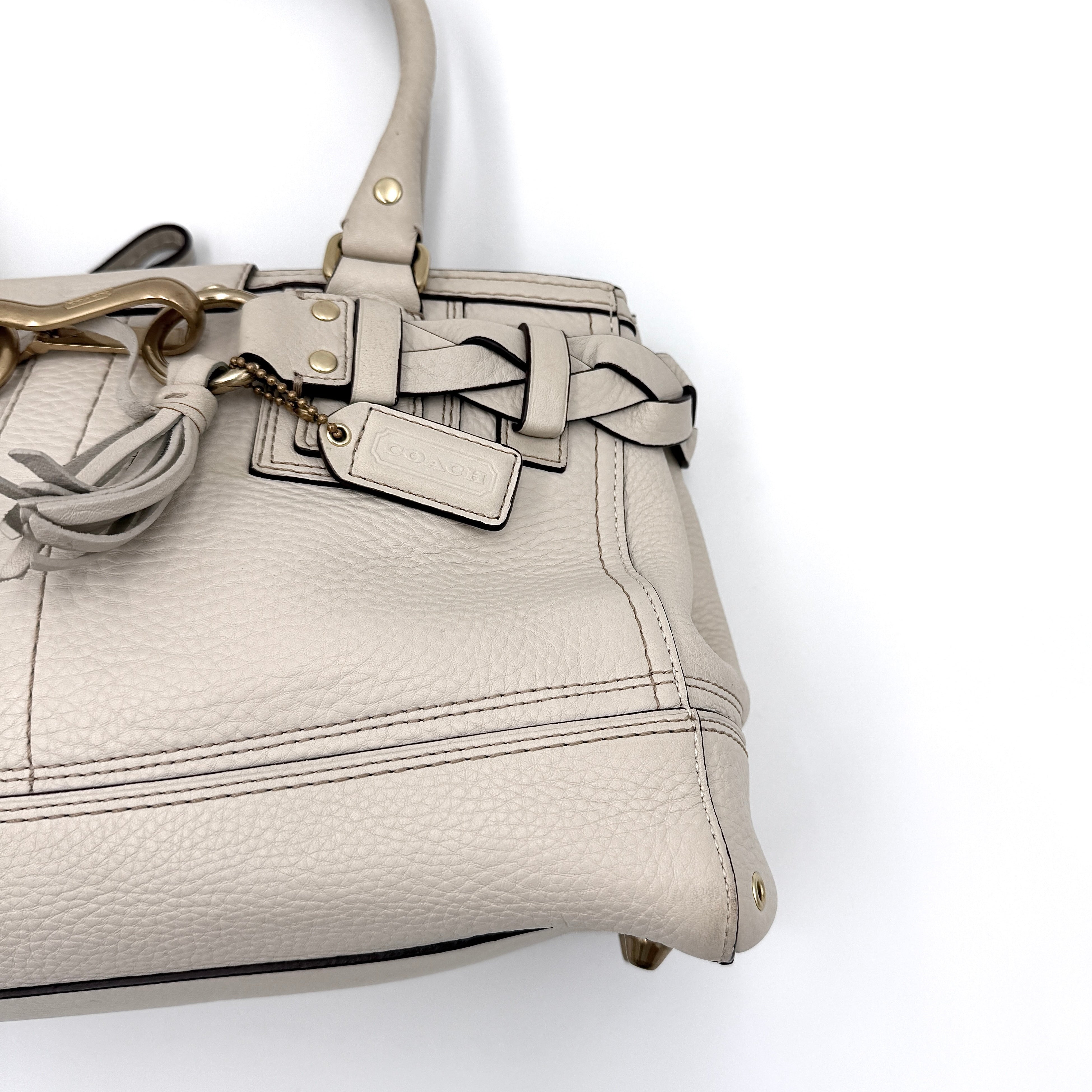Coach Signature Hampton Carryall Shoulder Bag in ivory pebbled leather with gold-tone hardware and braided detailing, shown from the front.