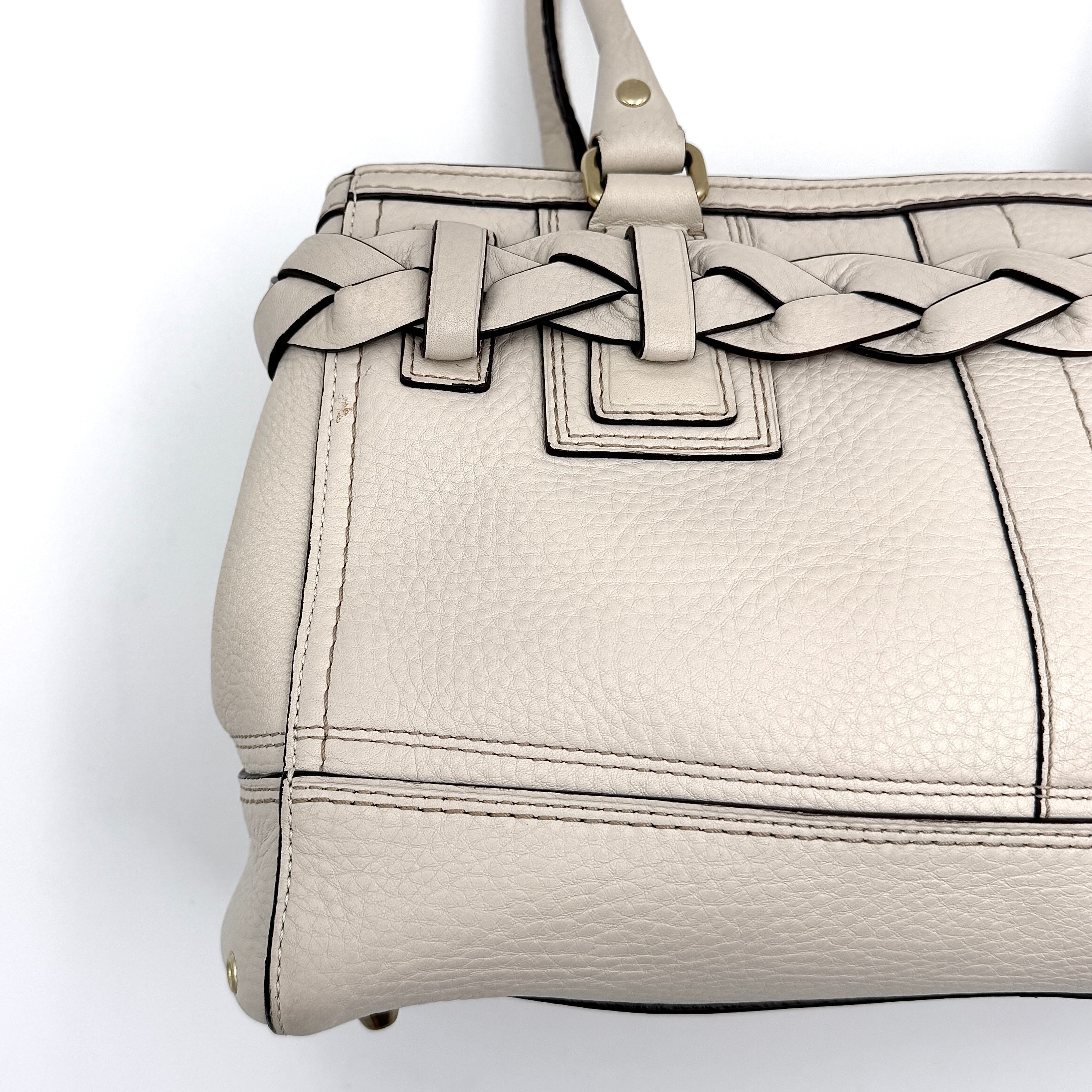 Coach Signature Hampton Carryall Shoulder Bag in ivory pebbled leather with gold-tone hardware and braided detailing, shown from the front.