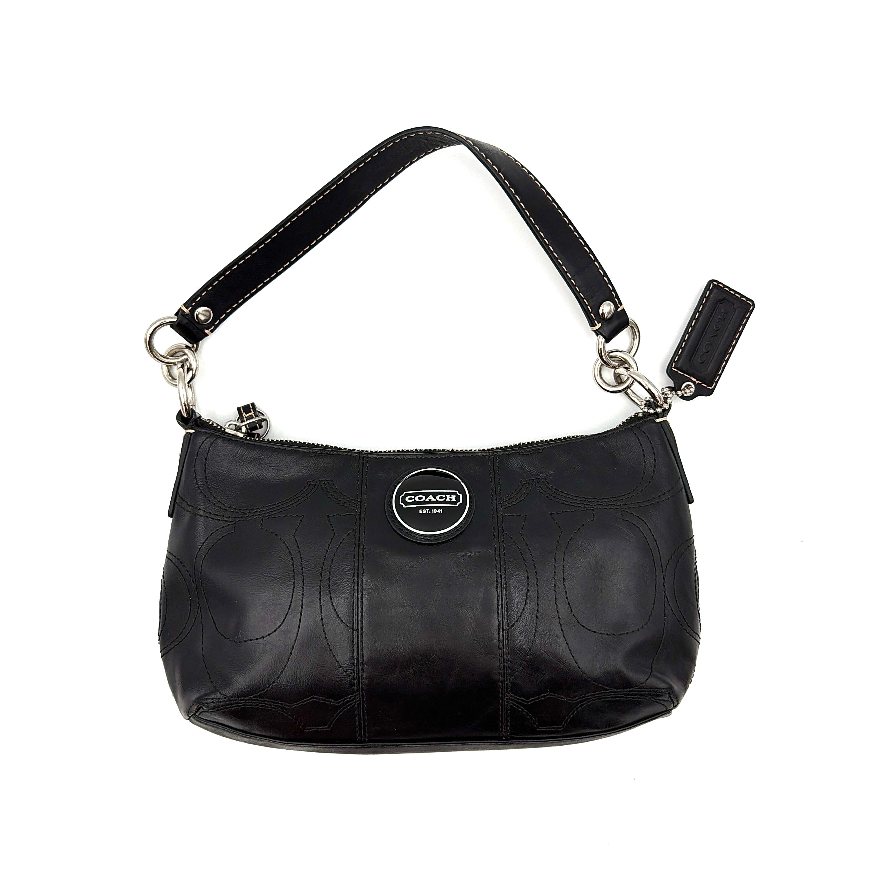 Coach black leather shoulder bag with signature embossed pattern and silver hardware, shown with attached logo tag and short leather strap.