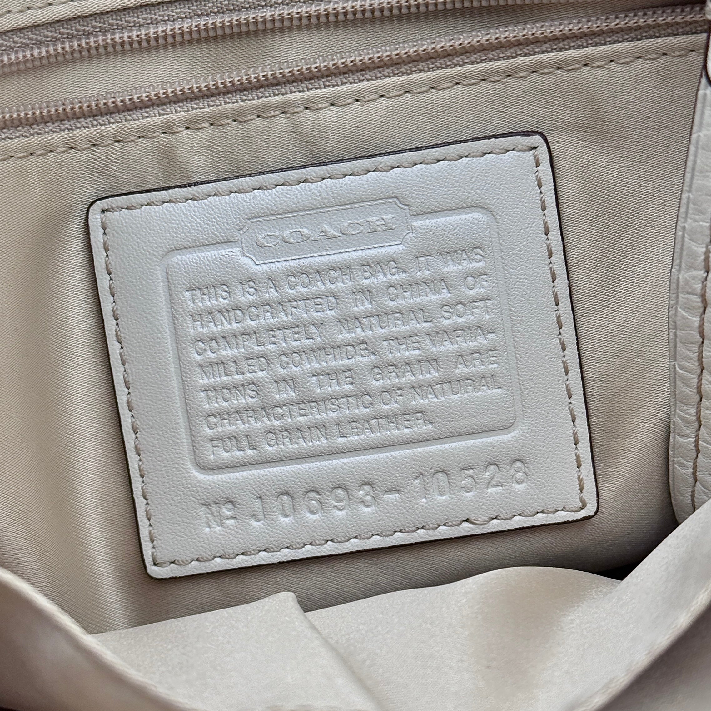 Coach Signature Hampton Carryall Shoulder Bag in ivory pebbled leather with gold-tone hardware and braided detailing, shown from the front.