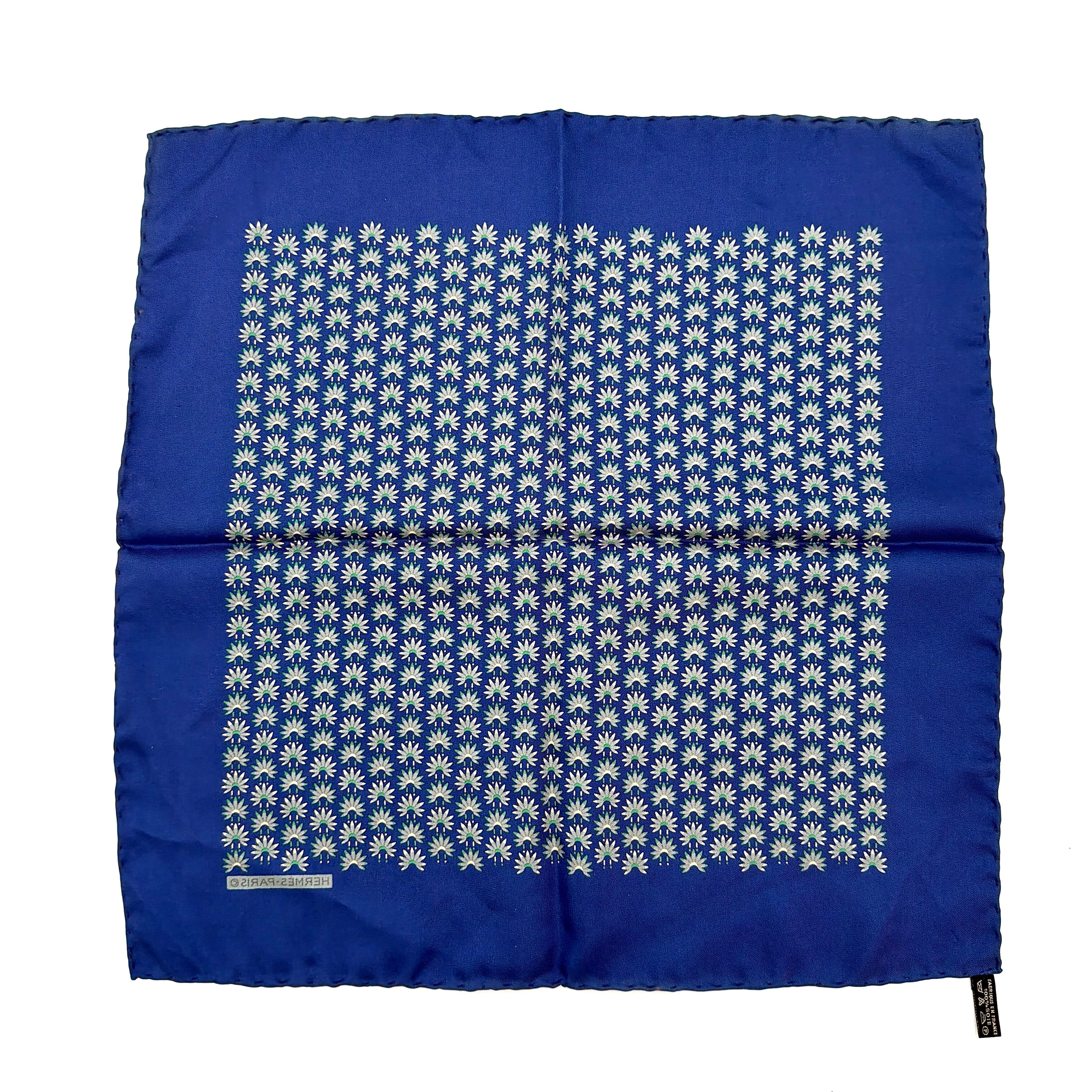 Hermès silk scarf in vibrant blue, featuring a precise all-over floral pattern and hand-rolled edges.