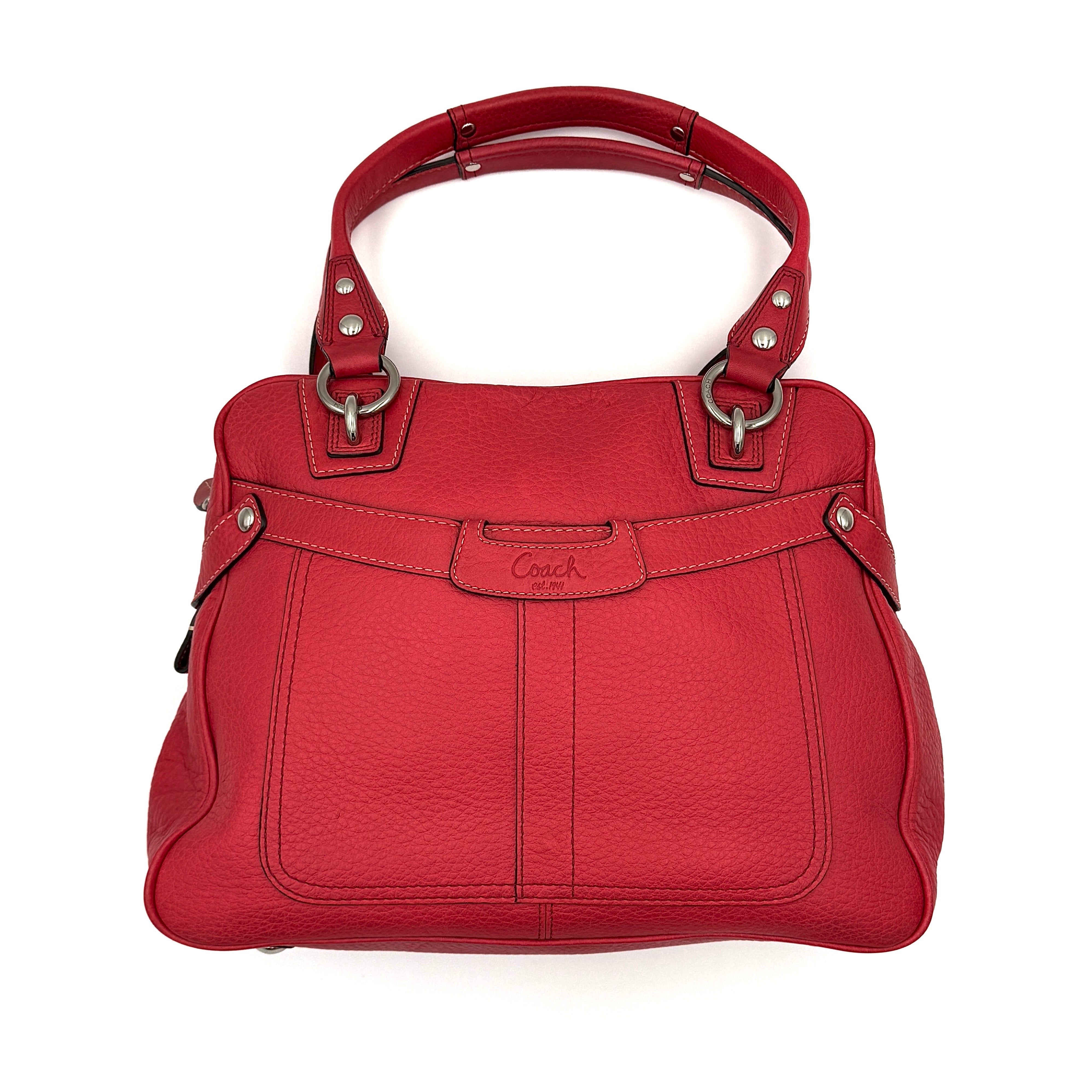 Coach red pebbled leather satchel with dual rolled handles, silver hardware, and structured silhouette.