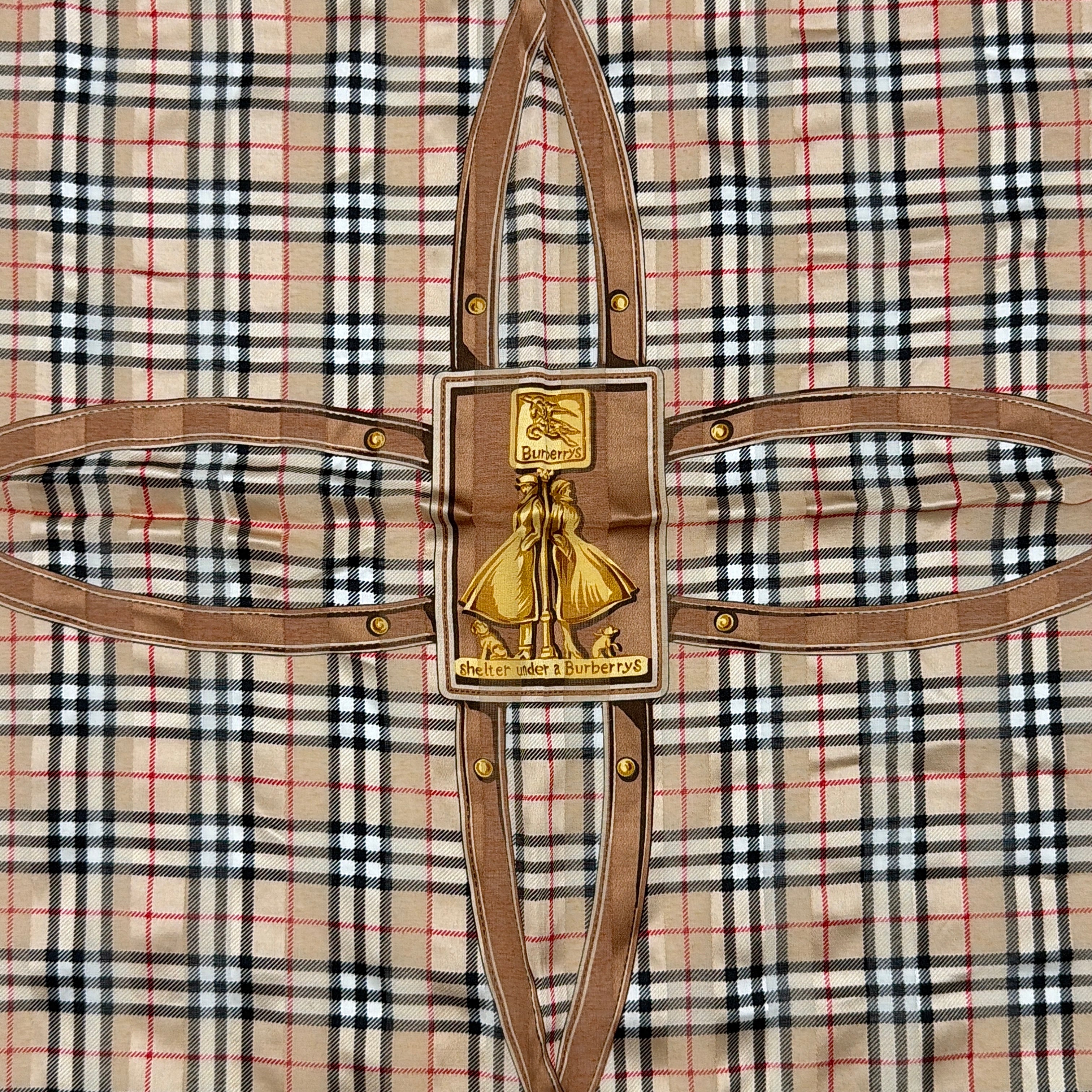 Editorial image of a Burberry silk bandana featuring Nova Check and equestrian-inspired harness motif in beige and gold tones.