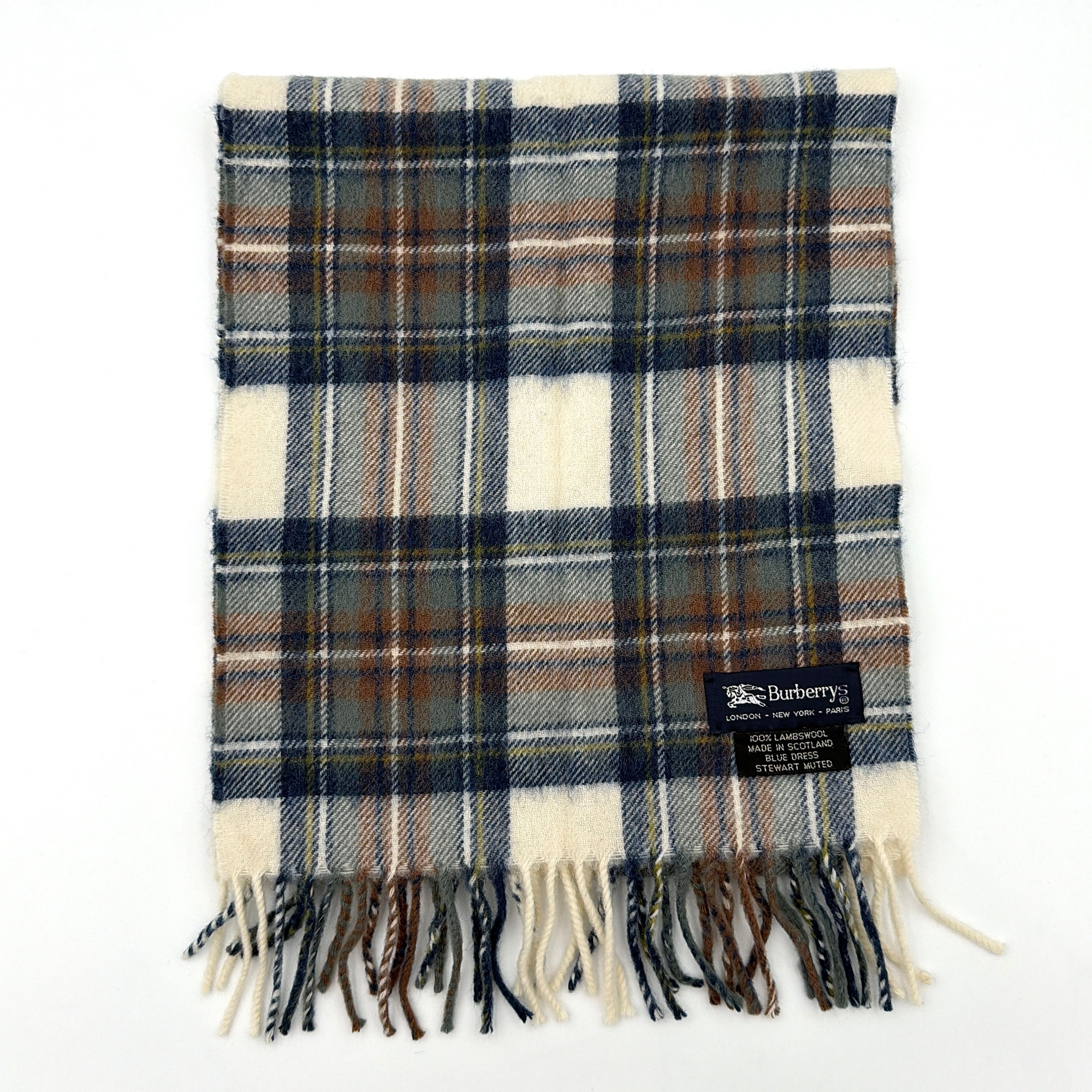 Burberry wool scarf in a muted blue, cream, and grey Stewart tartan, finished with long fringe and a woven heritage label.