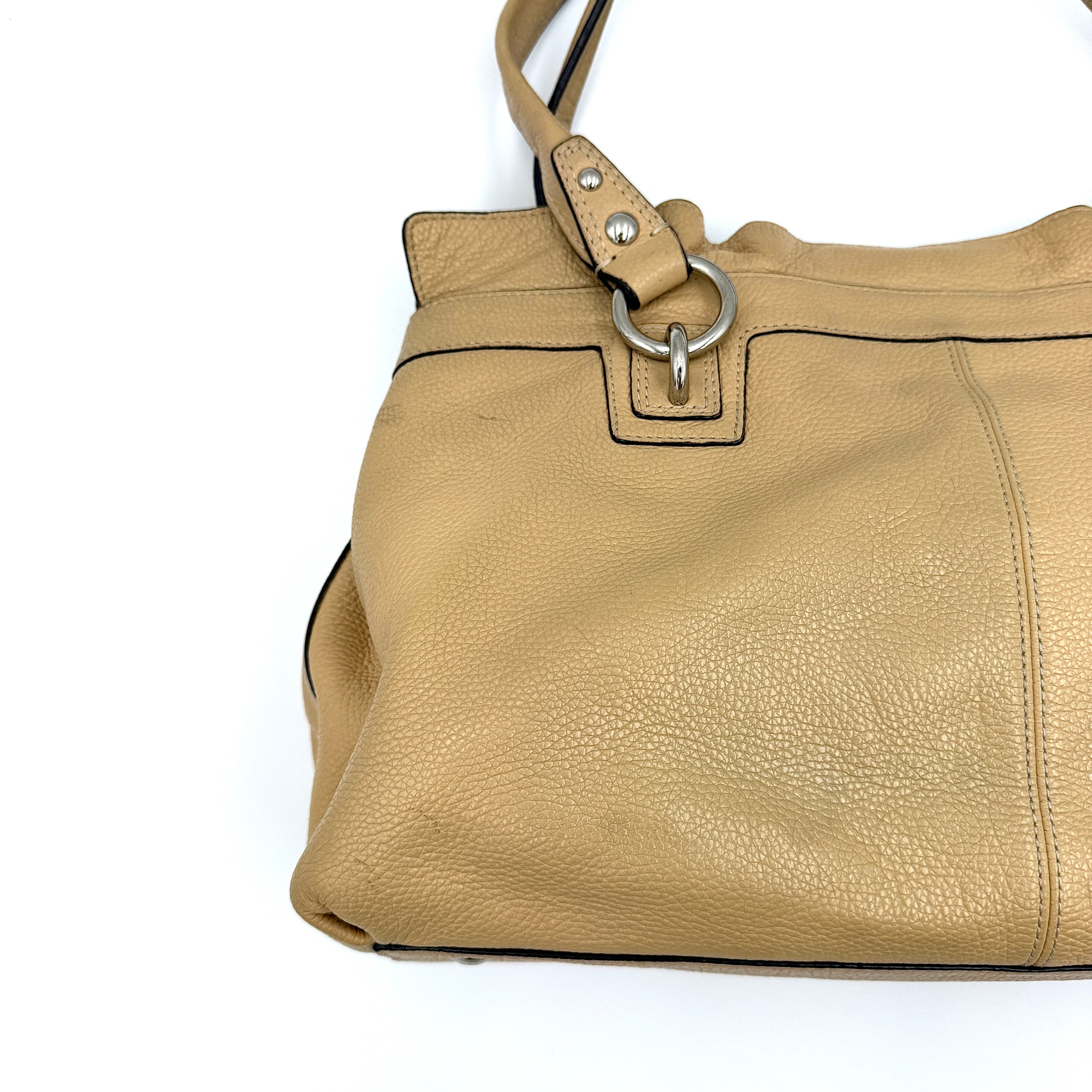 Coach Penelope handbag in cream pebble leather with rolled handles and silver-tone hardware against a white background.