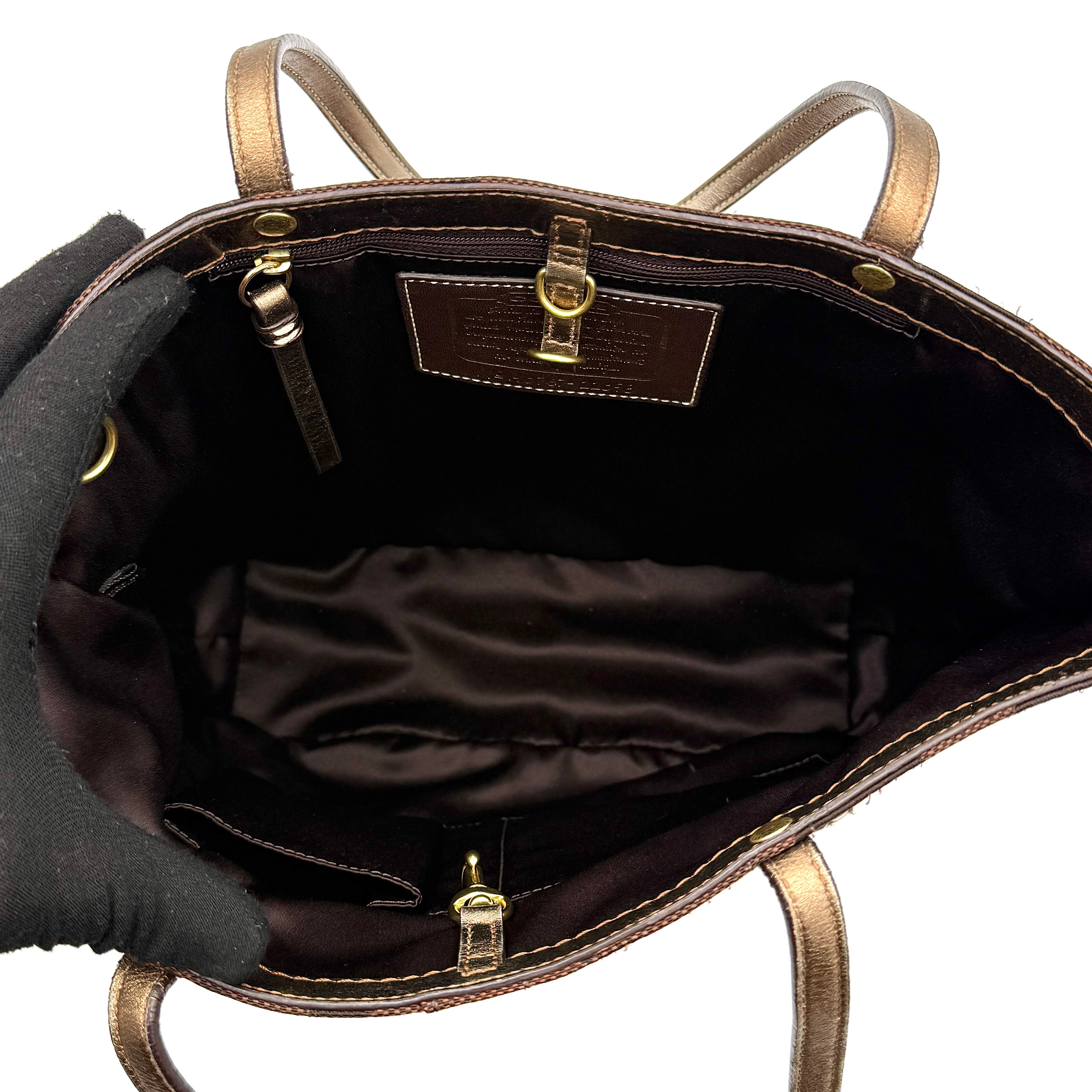 Coach Signature Stripe Tote Bag in rich brown monogram canvas with metallic gold leather handles, photographed upright against a clean background.