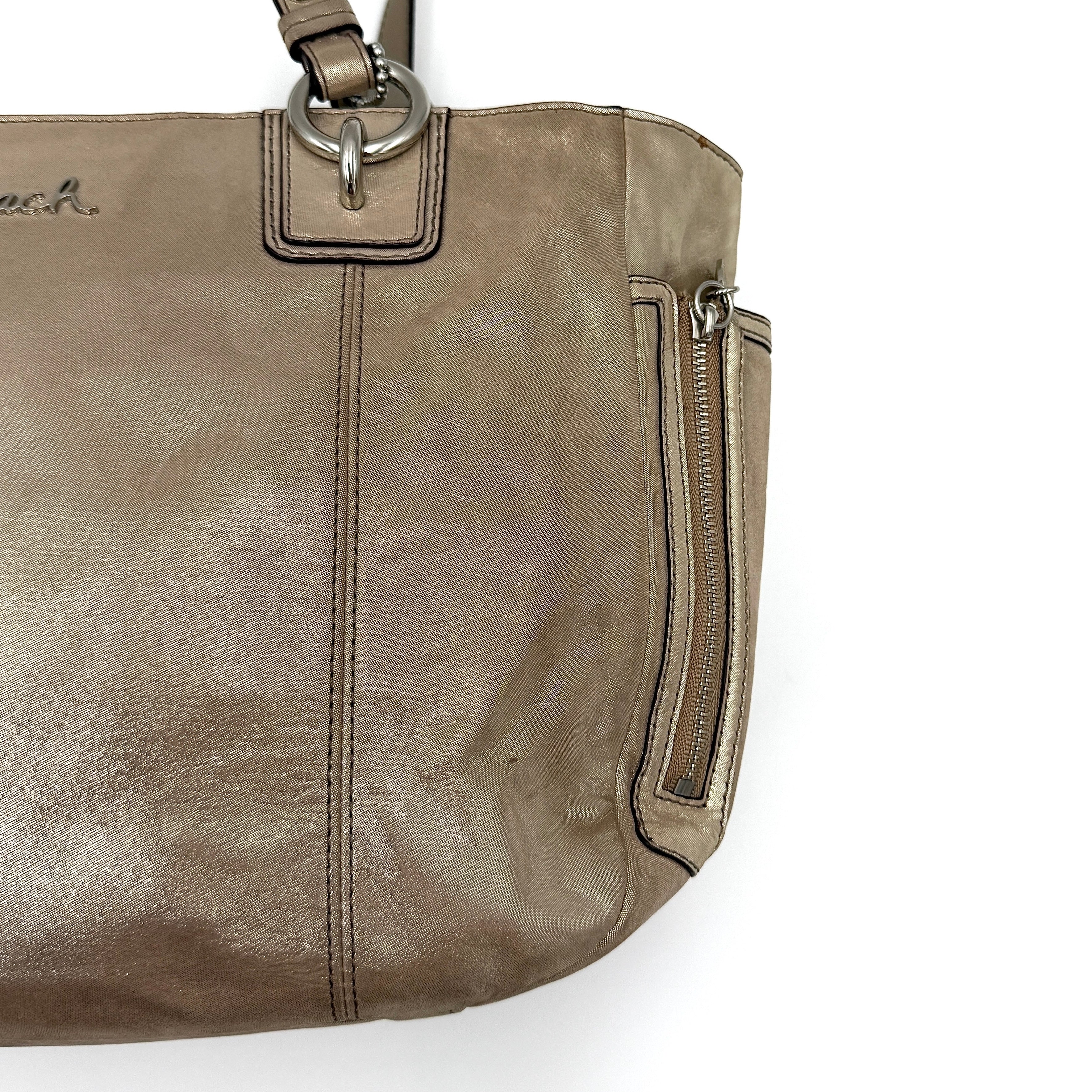 Coach Shimmer Gallery Tote in metallic beige leather with silver-tone hardware and dual top handles, set against a white background.