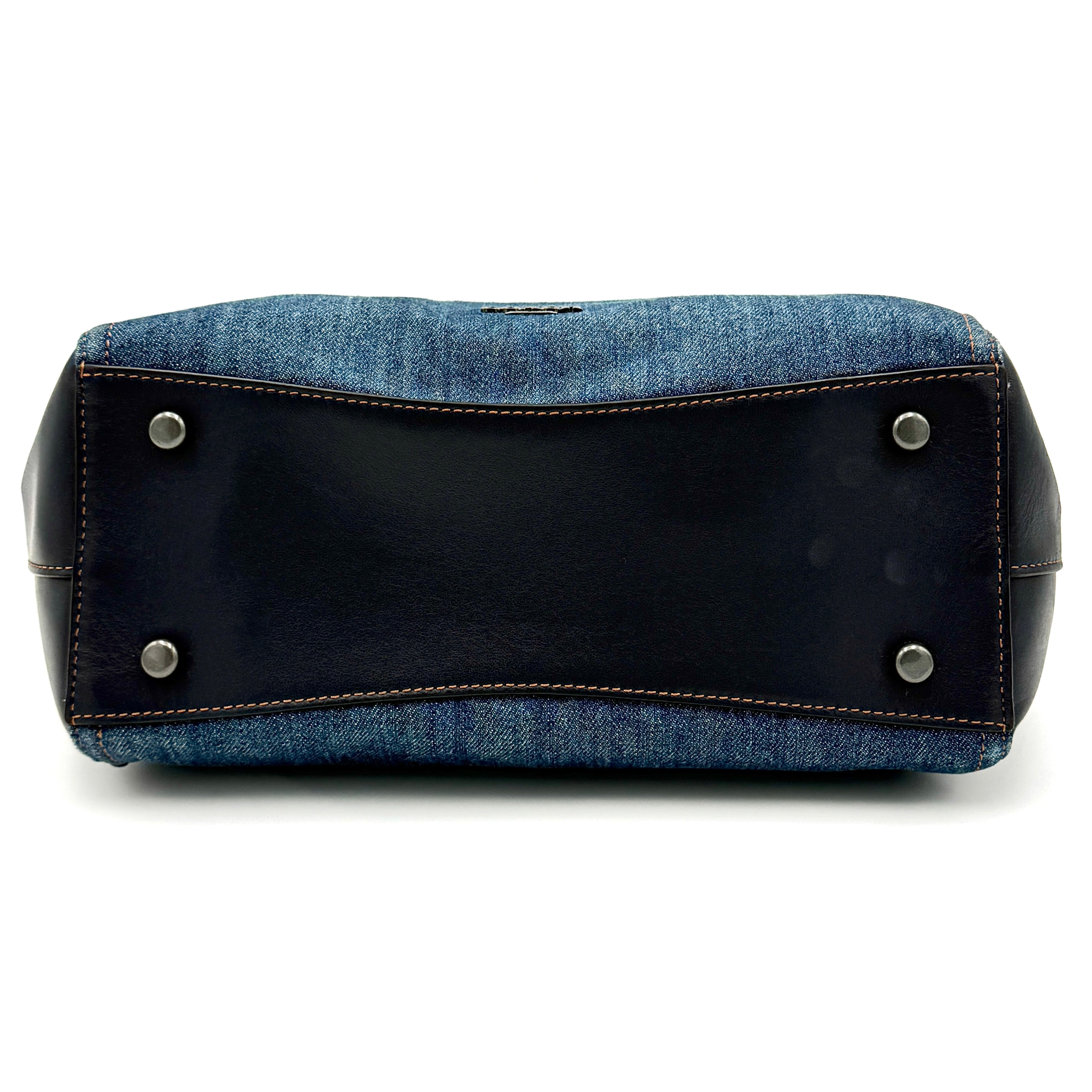 Coach Swagger 27 handbag in blue denim with navy leather trim and detachable strap, featuring prominent double turn-lock hardware and floral interior.