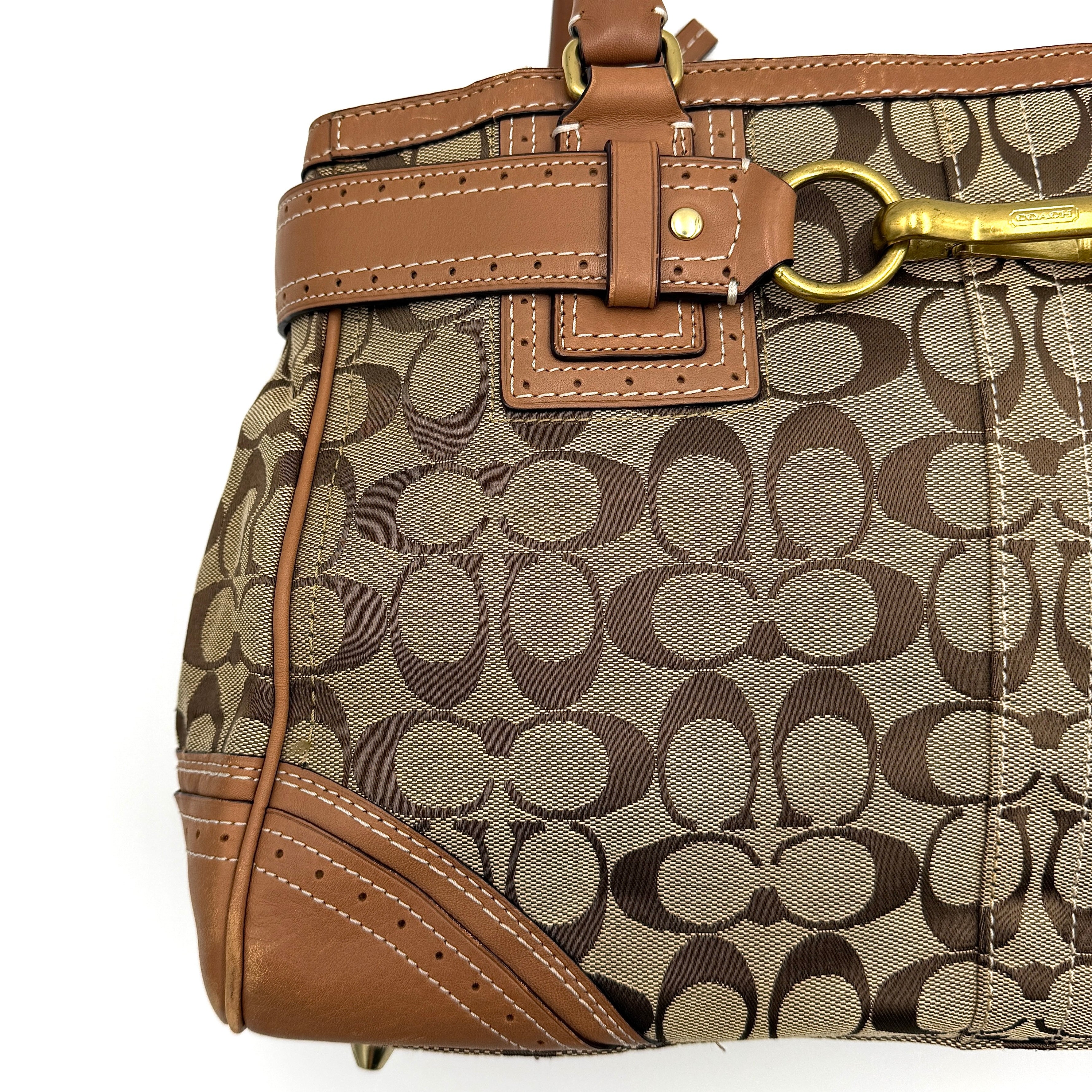 Coach Signature Hampton Carryall Shoulder Bag in beige and tan canvas with caramel leather trim, gold hardware, and tassel detail, shown standing upright.