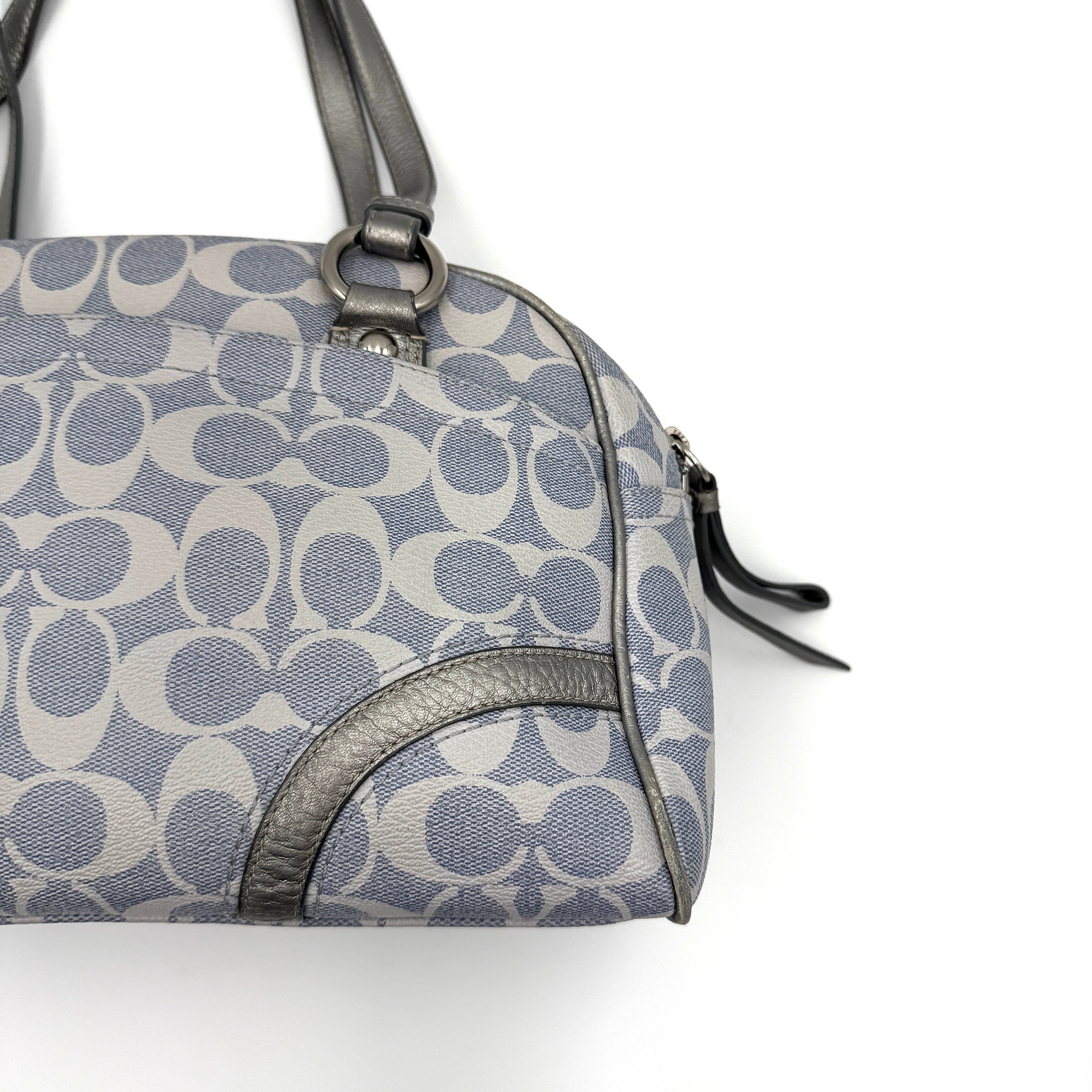 Coach Signature Peyton Satchel in light blue and grey canvas with metallic leather trim and double handles, shown against a white background.