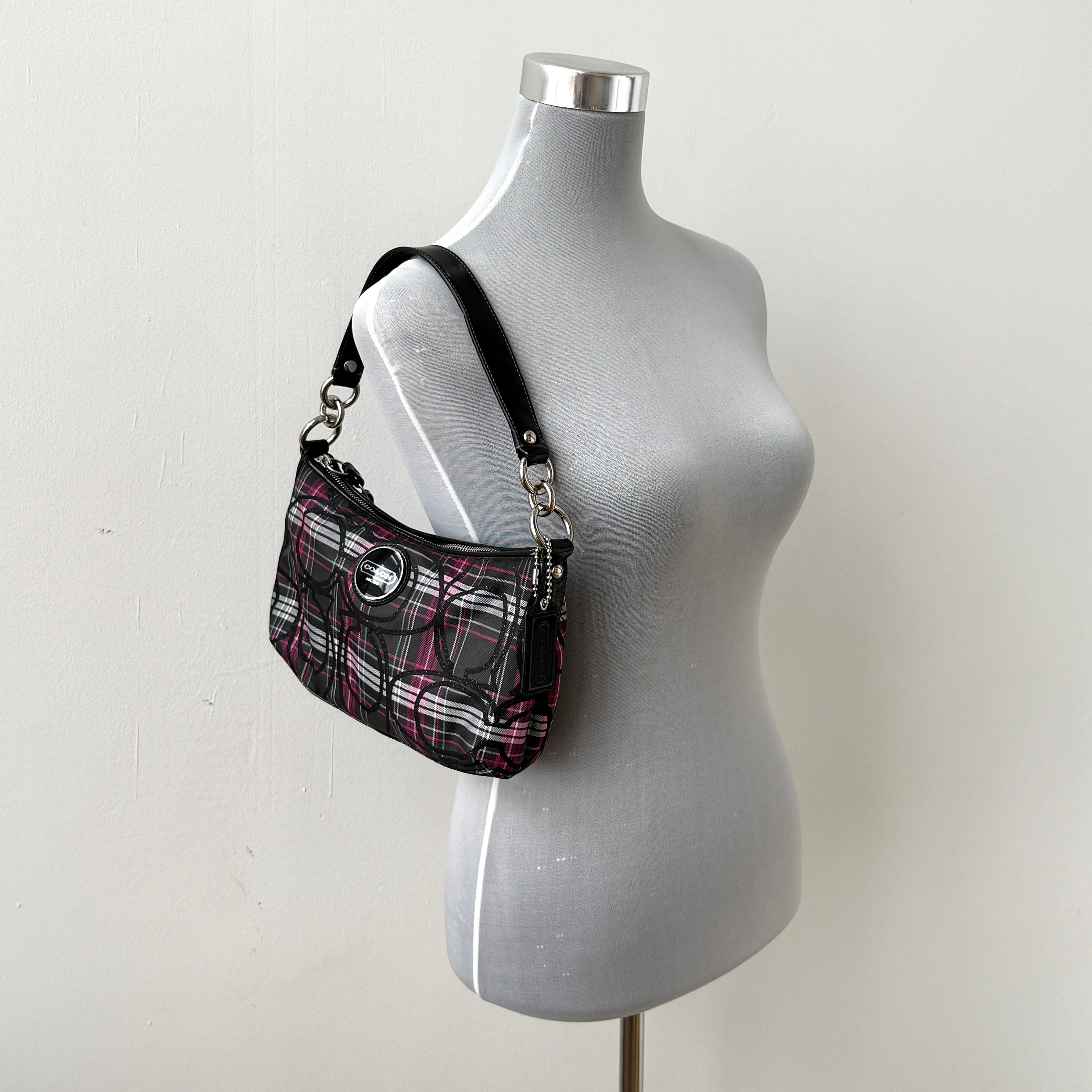 Coach Poppy tartan shoulder bag in black, magenta, and teal plaid with detachable black leather strap and silver-tone hardware.