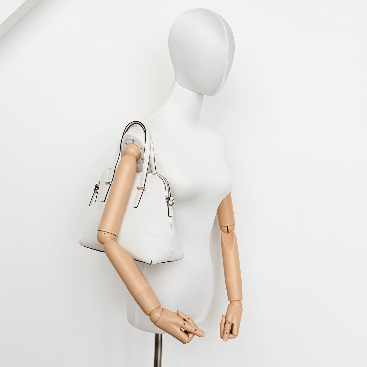 Top view of the Kate Spade Cedar Street Maise satchel in ivory, showing its spacious polka dot interior and zip pocket detail.