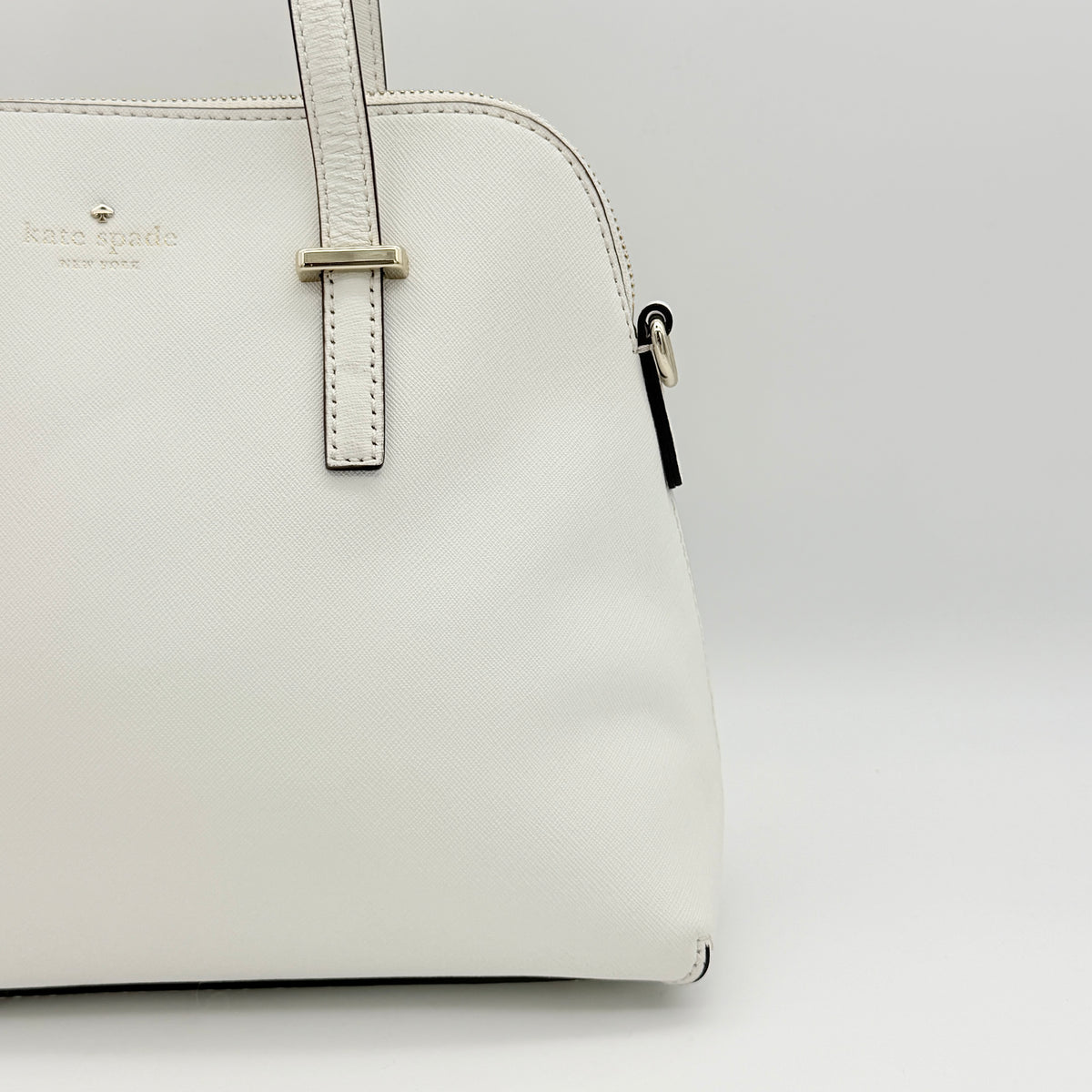 Top view of the Kate Spade Cedar Street Maise satchel in ivory, showing its spacious polka dot interior and zip pocket detail.