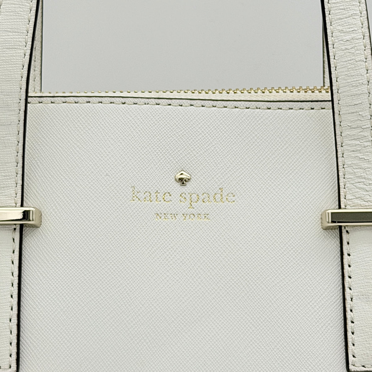 Top view of the Kate Spade Cedar Street Maise satchel in ivory, showing its spacious polka dot interior and zip pocket detail.