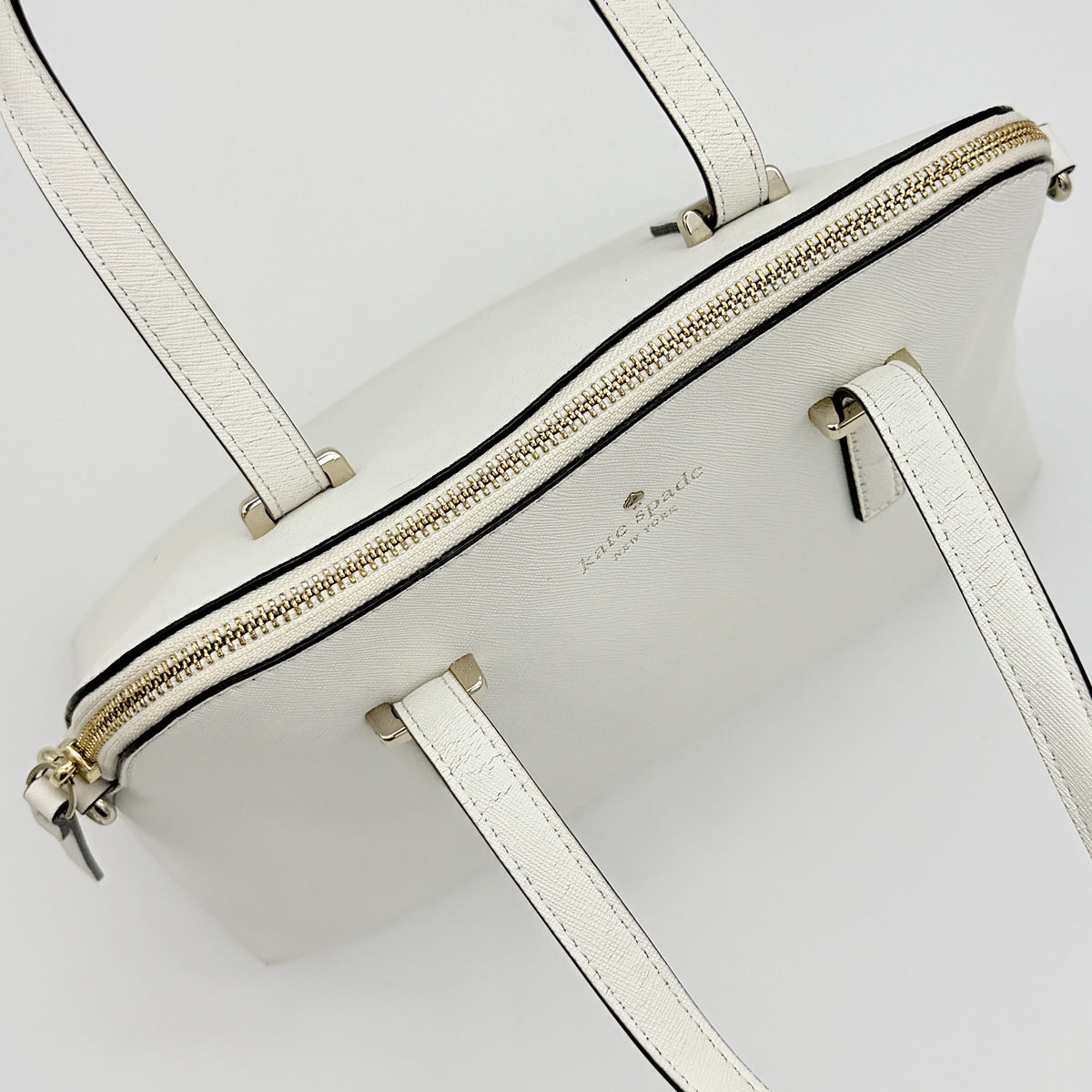 Top view of the Kate Spade Cedar Street Maise satchel in ivory, showing its spacious polka dot interior and zip pocket detail.