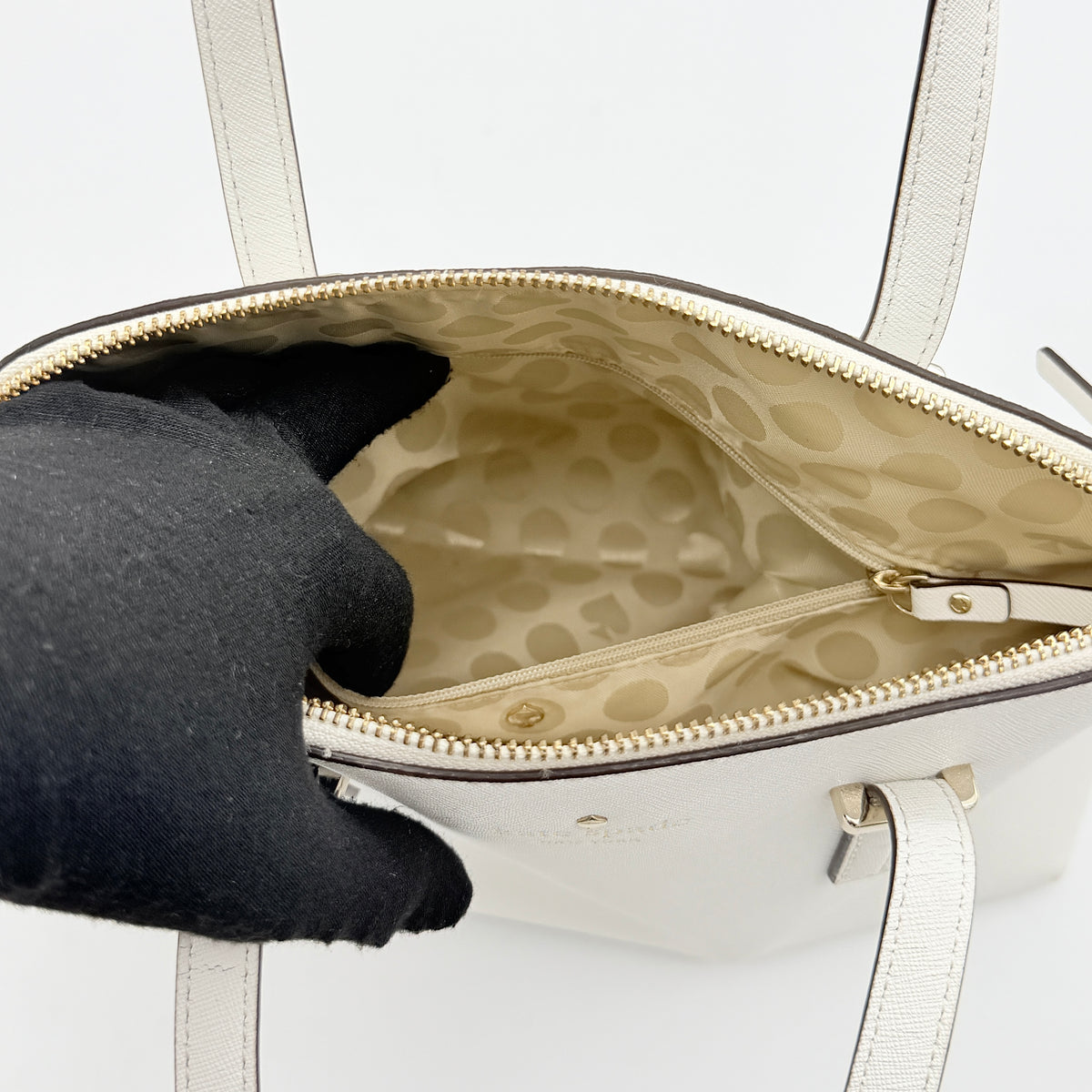 Top view of the Kate Spade Cedar Street Maise satchel in ivory, showing its spacious polka dot interior and zip pocket detail.