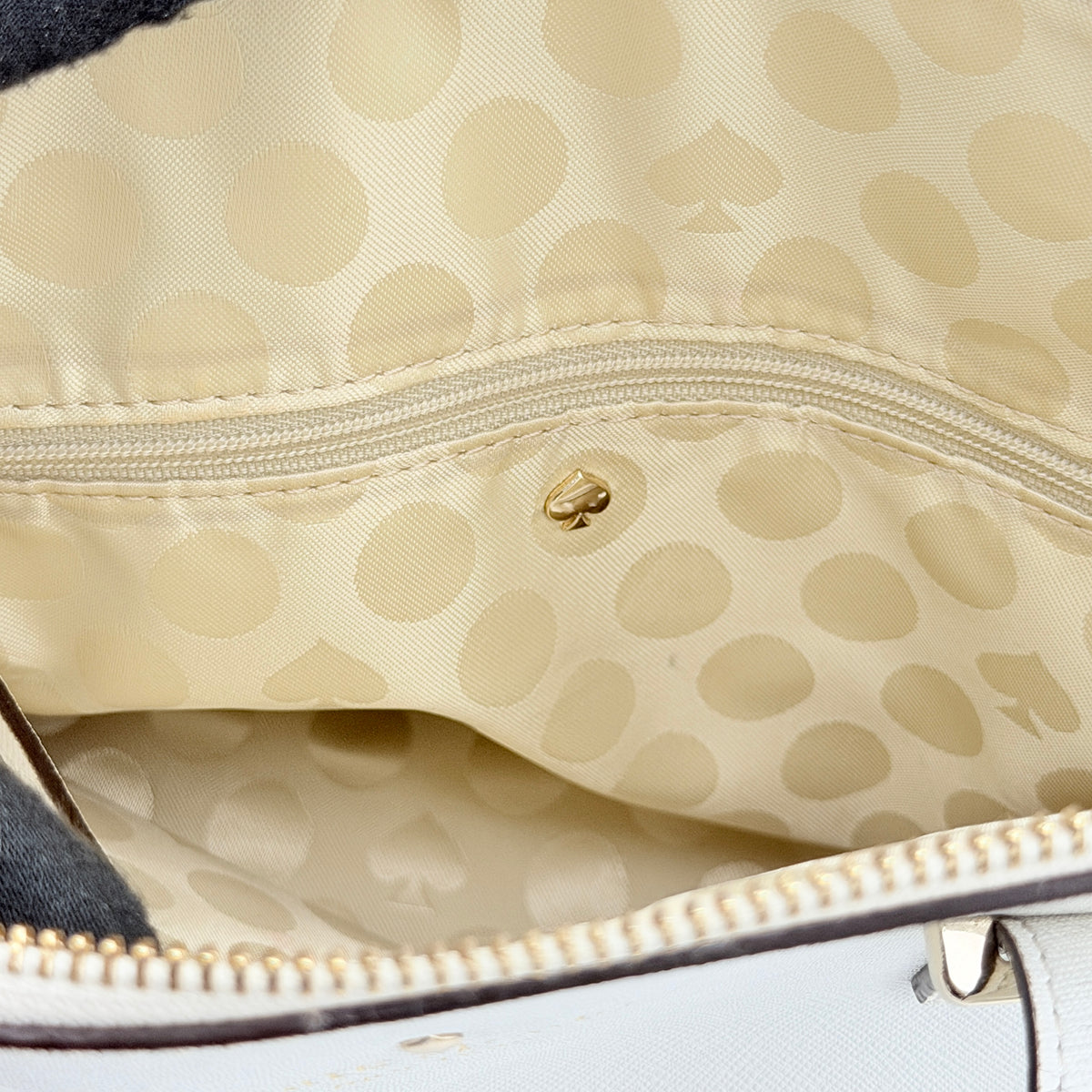 Top view of the Kate Spade Cedar Street Maise satchel in ivory, showing its spacious polka dot interior and zip pocket detail.