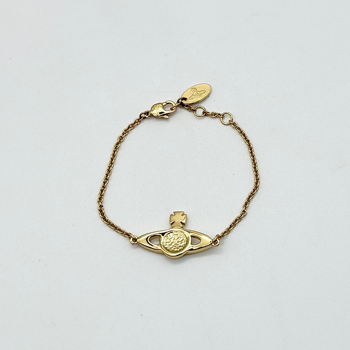 Vivienne Westwood gold rhinestone Orb bracelet with original box, dust bag, and authenticity card arranged on a white background.