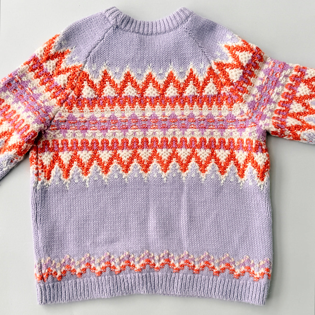 Coach Fair Isle Ski Sweater in lilac with orange and cream geometric pattern and COACH logo across the chest.