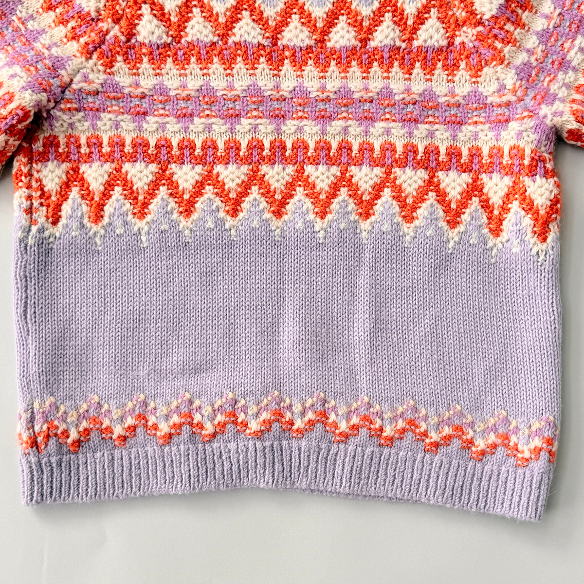 Coach Fair Isle Ski Sweater in lilac with orange and cream geometric pattern and COACH logo across the chest.
