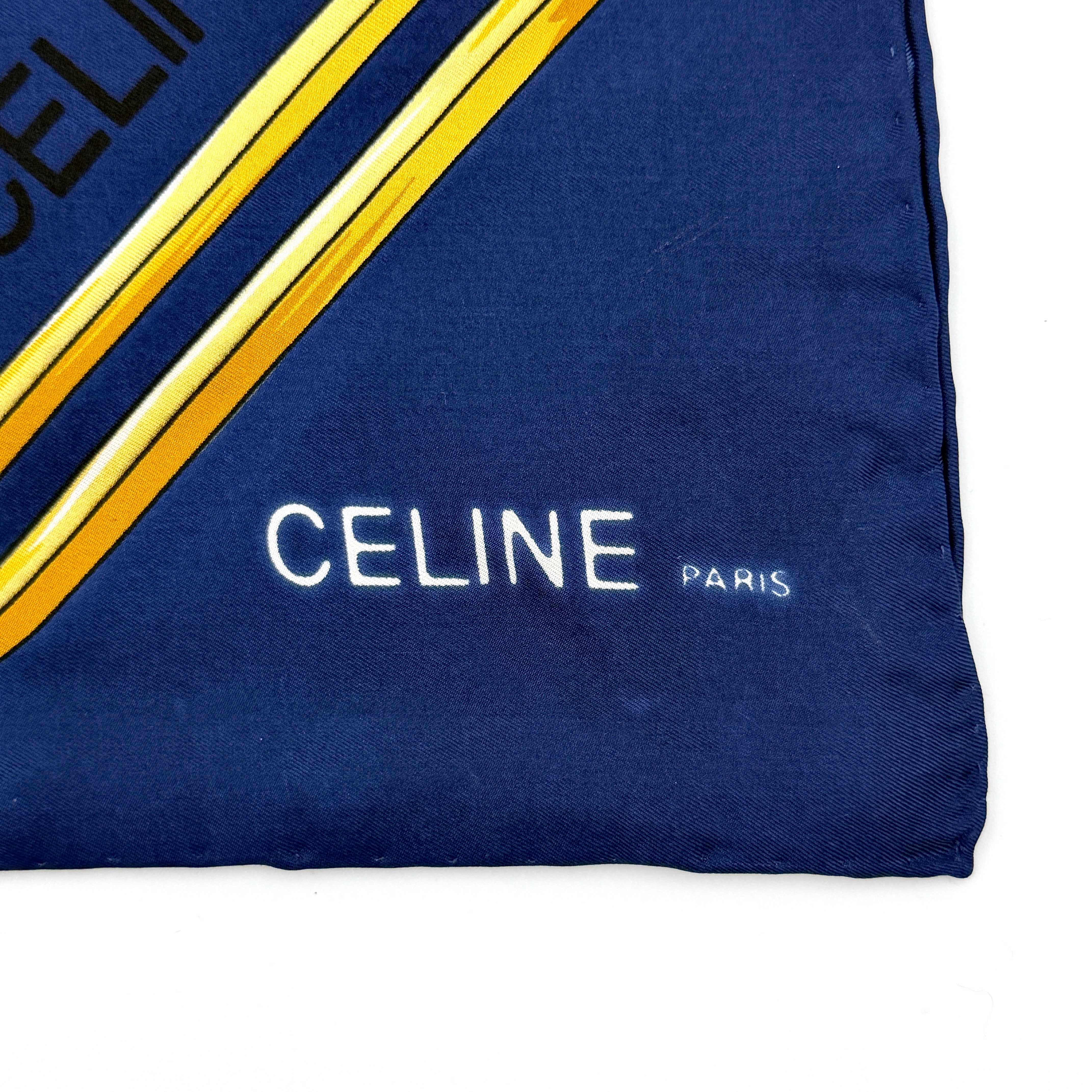 Celine silk scarf in navy blue with equestrian-inspired yellow and tan rein motif and carriage logo on silk.