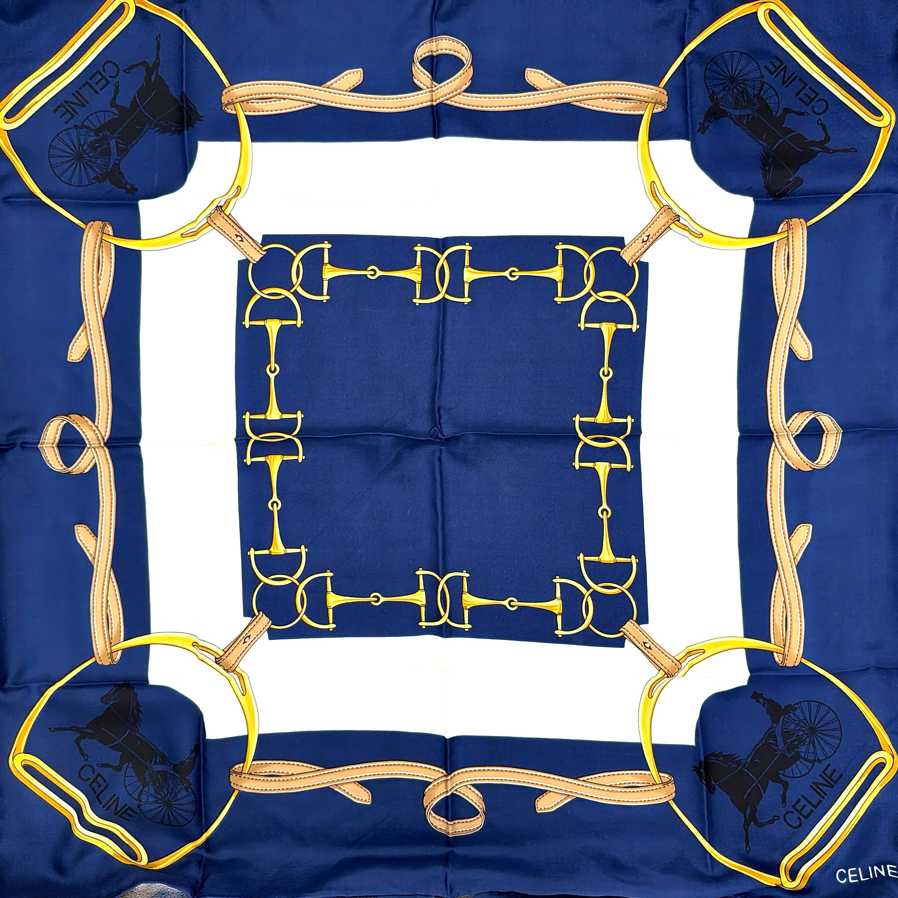 Celine silk scarf in navy blue with equestrian-inspired yellow and tan rein motif and carriage logo on silk.